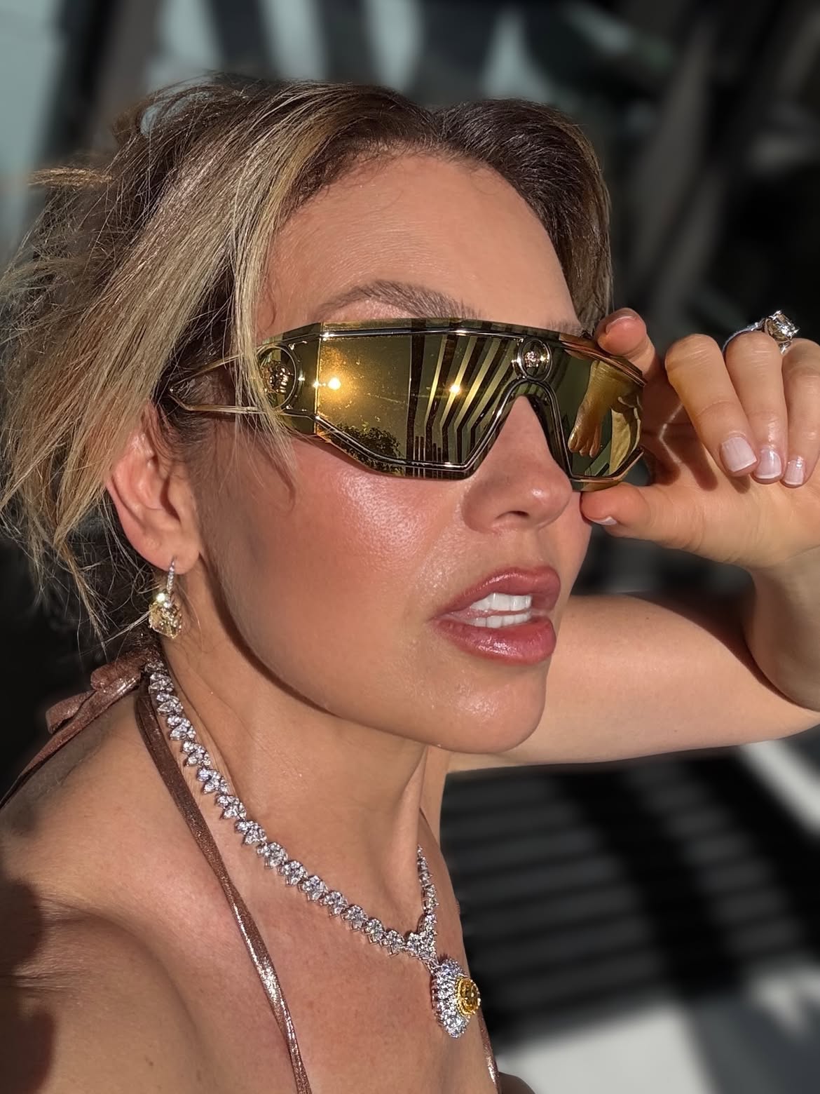 Thalía luciendo una microbikini metalizada en tono bronce acompañada por accesorios de alta gama | Fuente: Instagram/thalia
