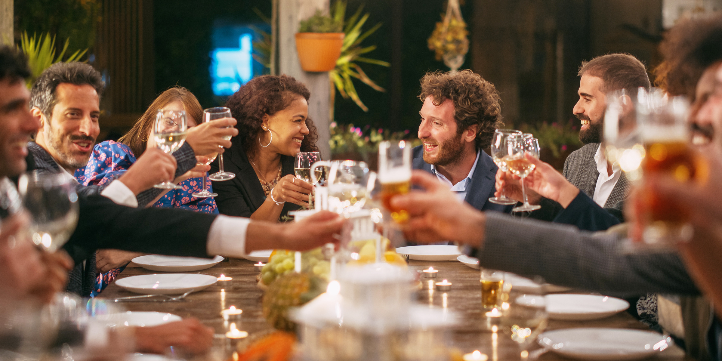 Invitados brindando en una cena | Fuente: Shutterstock