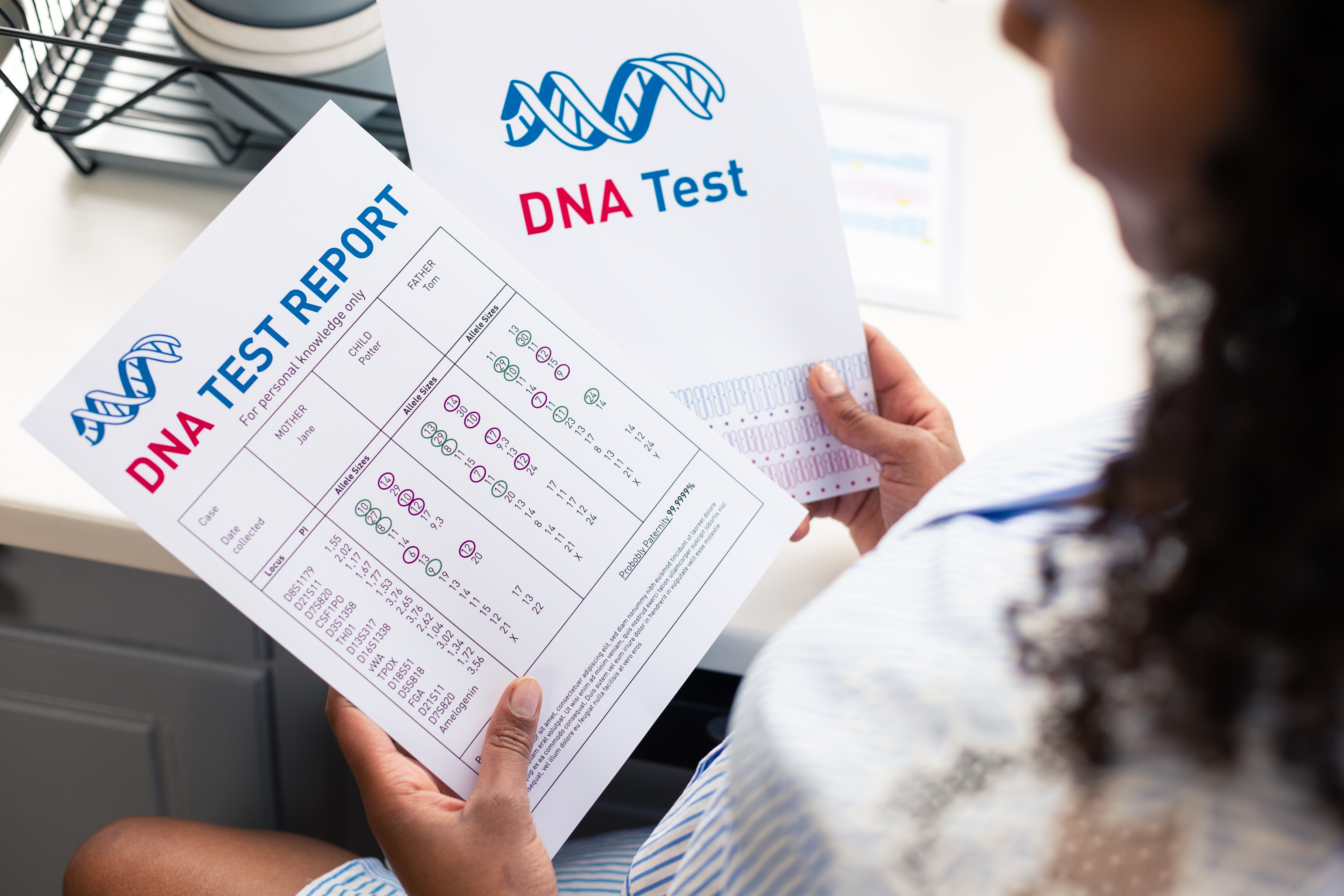 Una mujer sostiene y mira una prueba de ADN | Foto: Shutterstock
