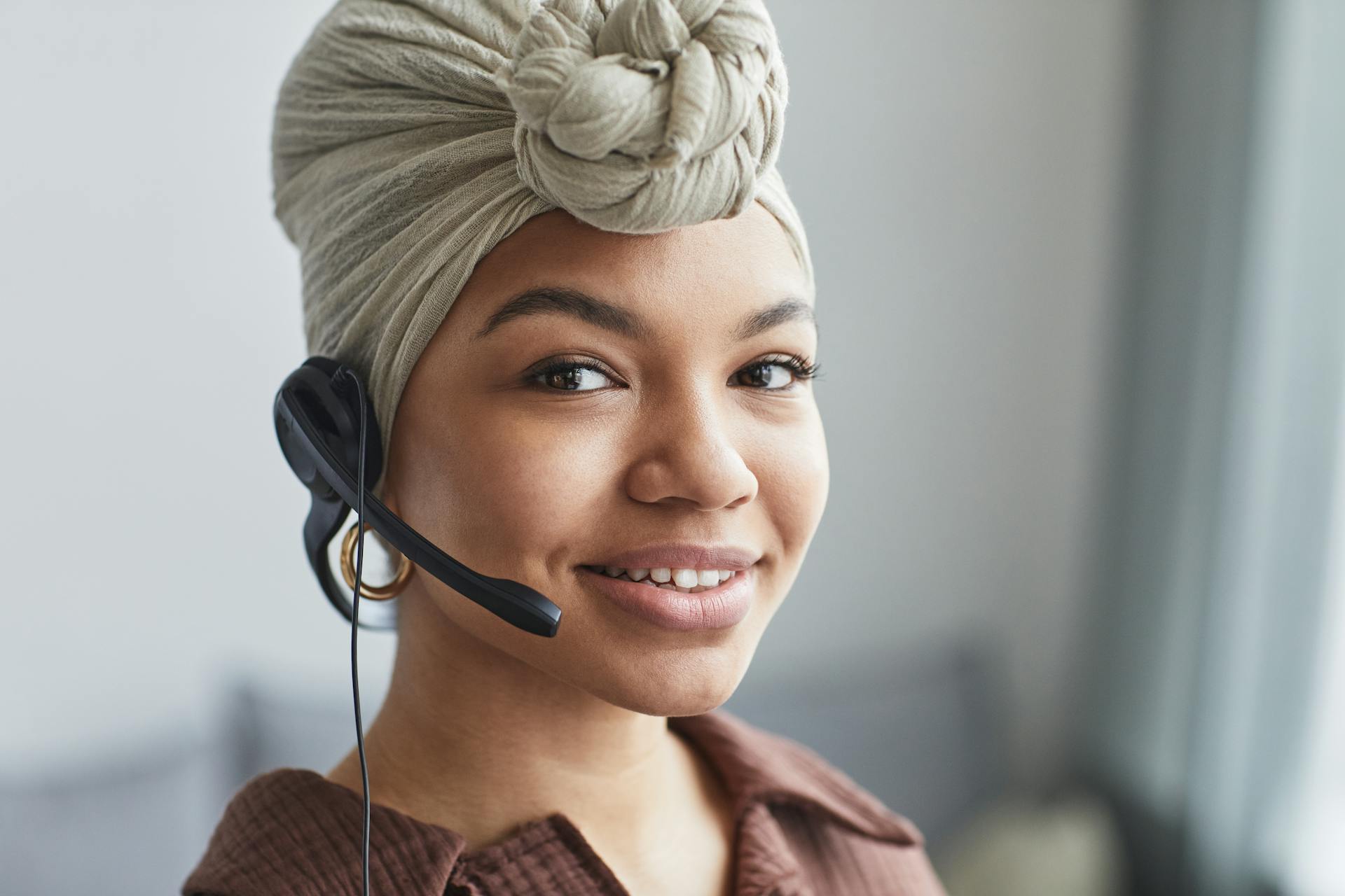 Una mujer hablando por el micrófono de unos auriculares | Fuente: Pexels