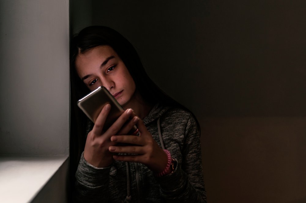 Mujer triste viendo su teléfono móvil. | Foto: Shutterstock.