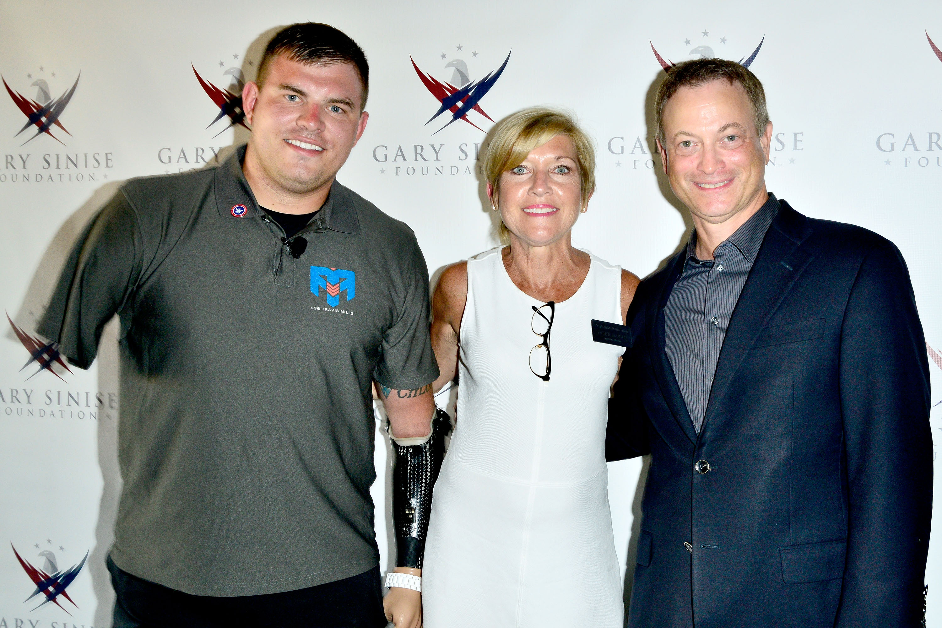 Travis Mills, la Directora Ejecutiva de la Fundación Gary Sinise, Judy Otter, y Gary Sinise asisten a la proyección benéfica "Travis: A Soldier's Story" en Coronado, California, el 8 de julio de 2014. | Fuente: Getty Images