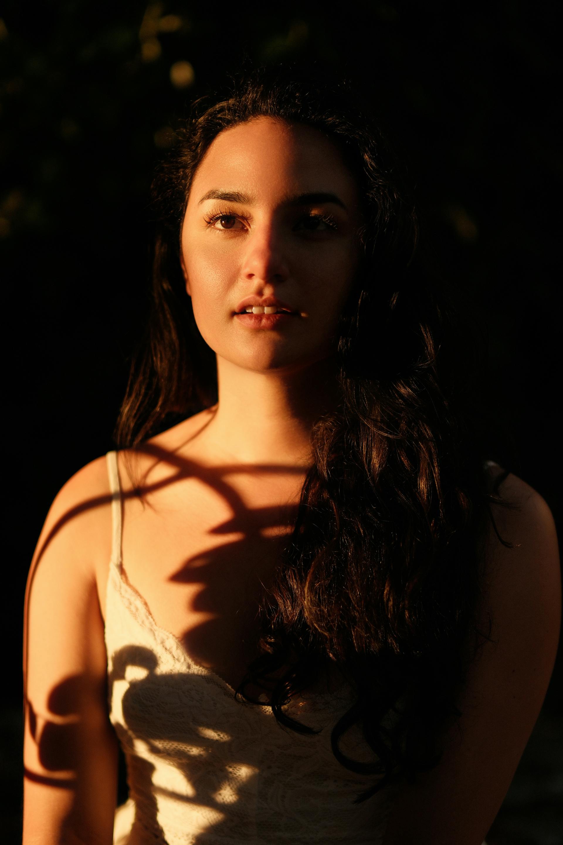 Retrato de una mujer joven con sombras que caen sobre su cuerpo | Fuente: Pexels