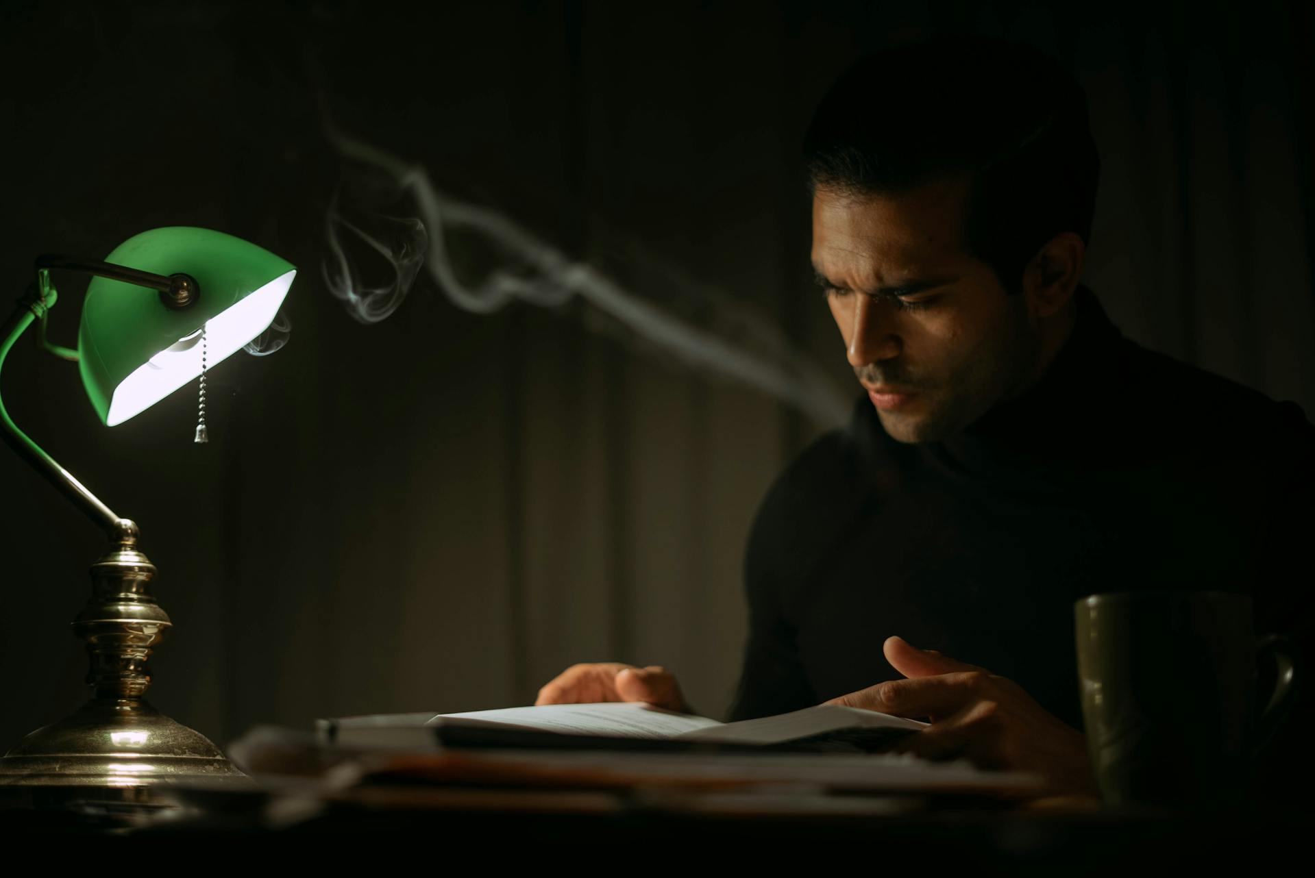 Un hombre leyendo un diario en una habitación oscura | Fuente: Pexels