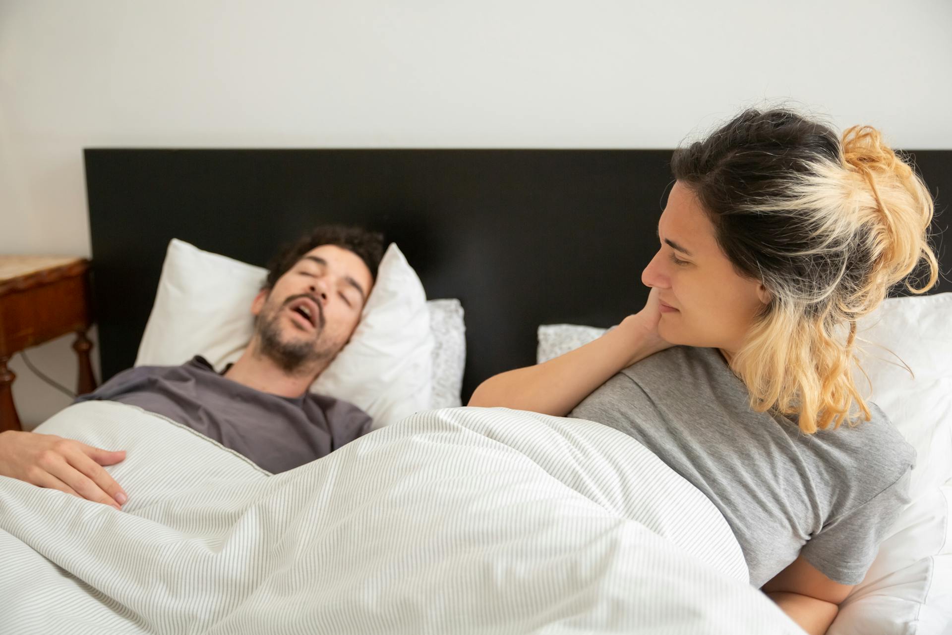 Una mujer mirando al hombre que duerme a su lado | Fuente: Pexels