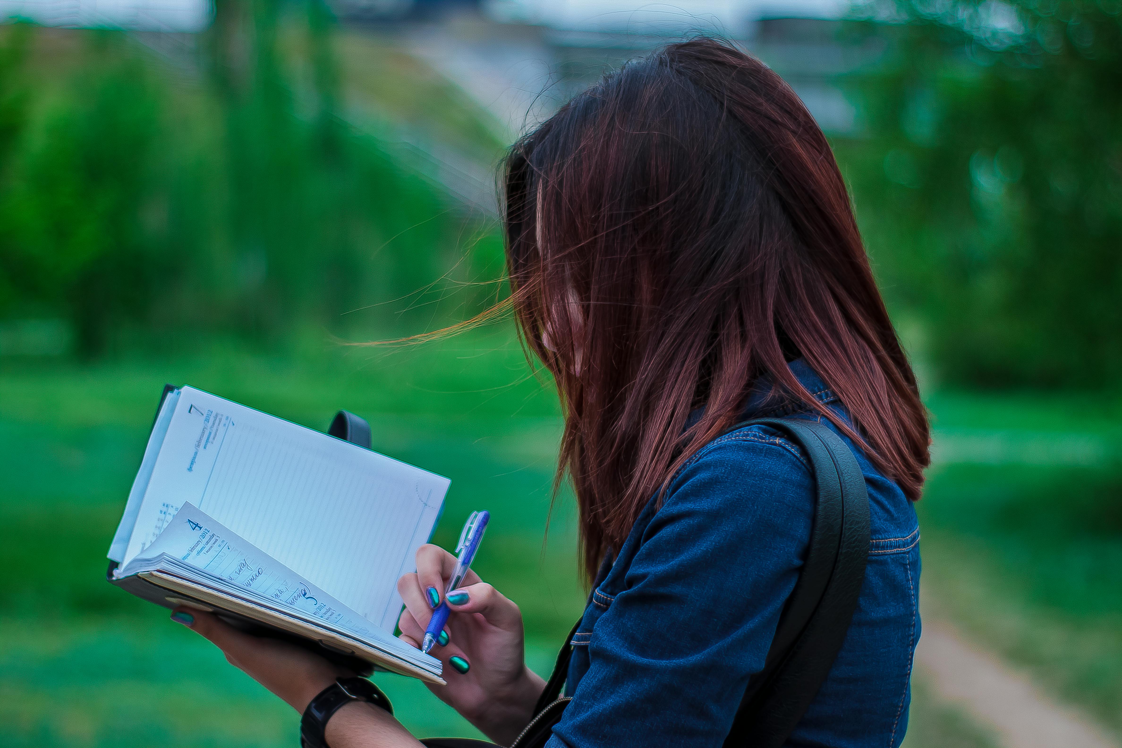 Una mujer escribiendo apresuradamente | Fuente: Pexels