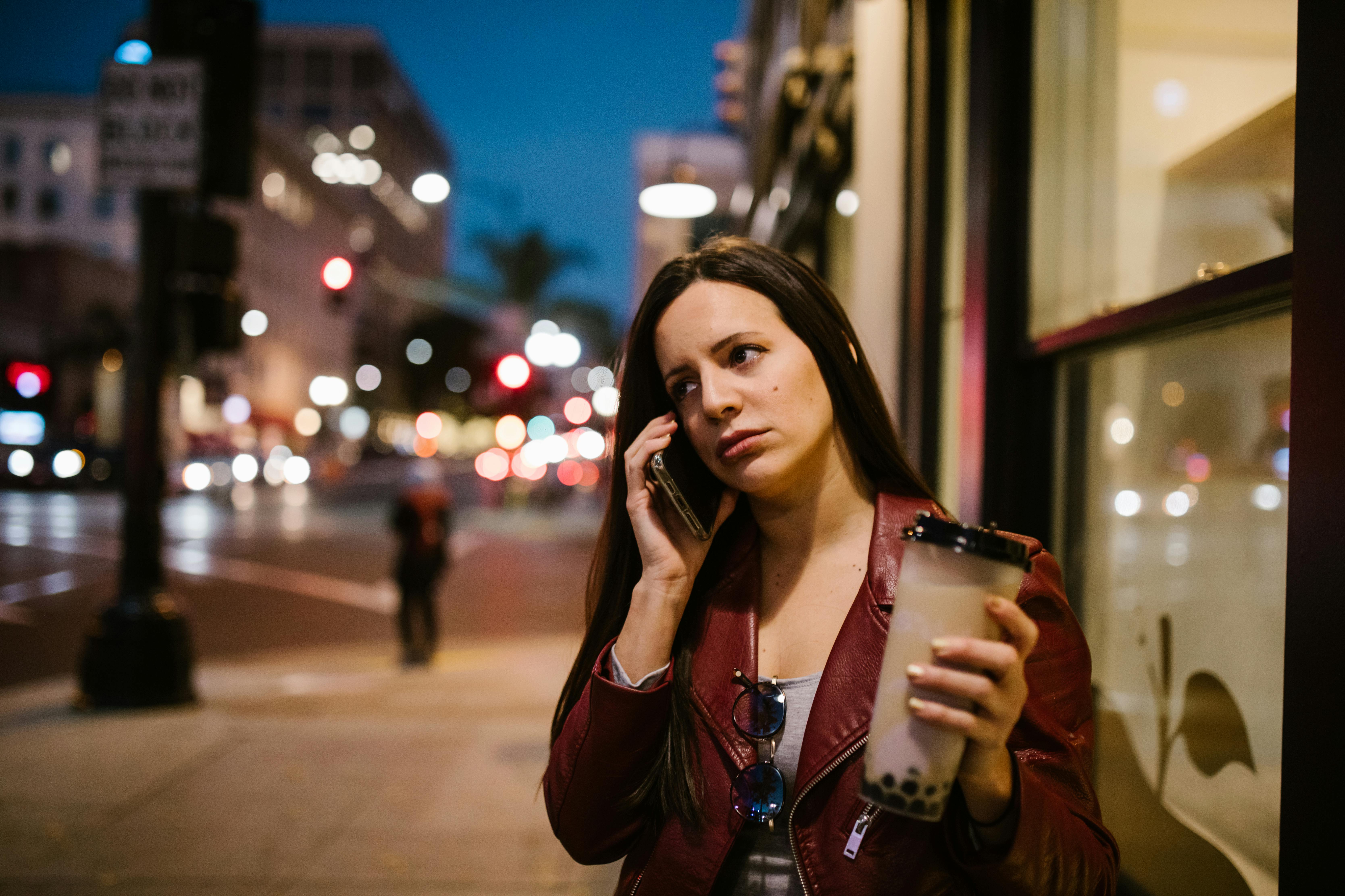 Una mujer hablando por teléfono en una acera | Foto: Pexels