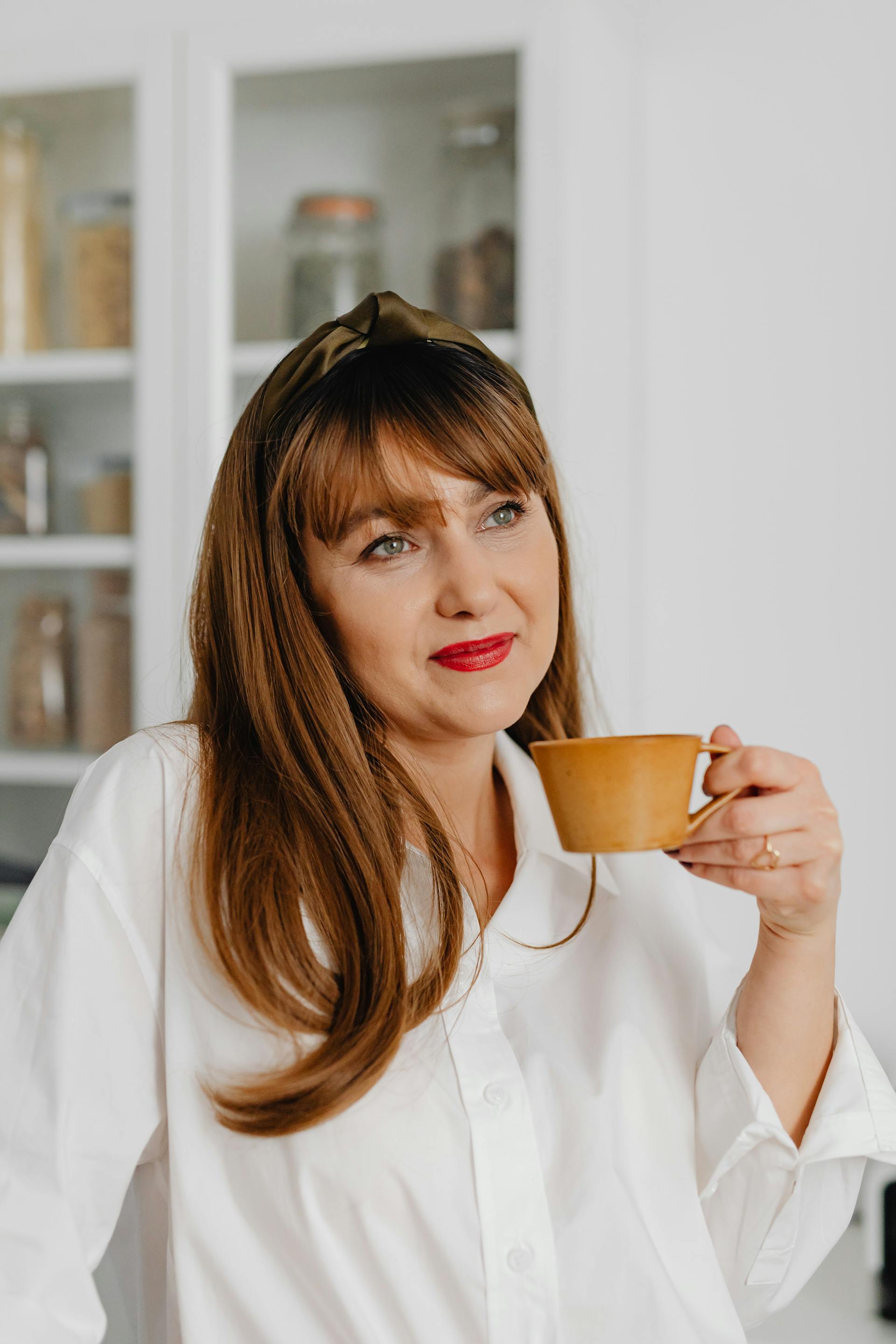 Una mujer alegre sosteniendo una taza de cerámica | Fuente: Pexels