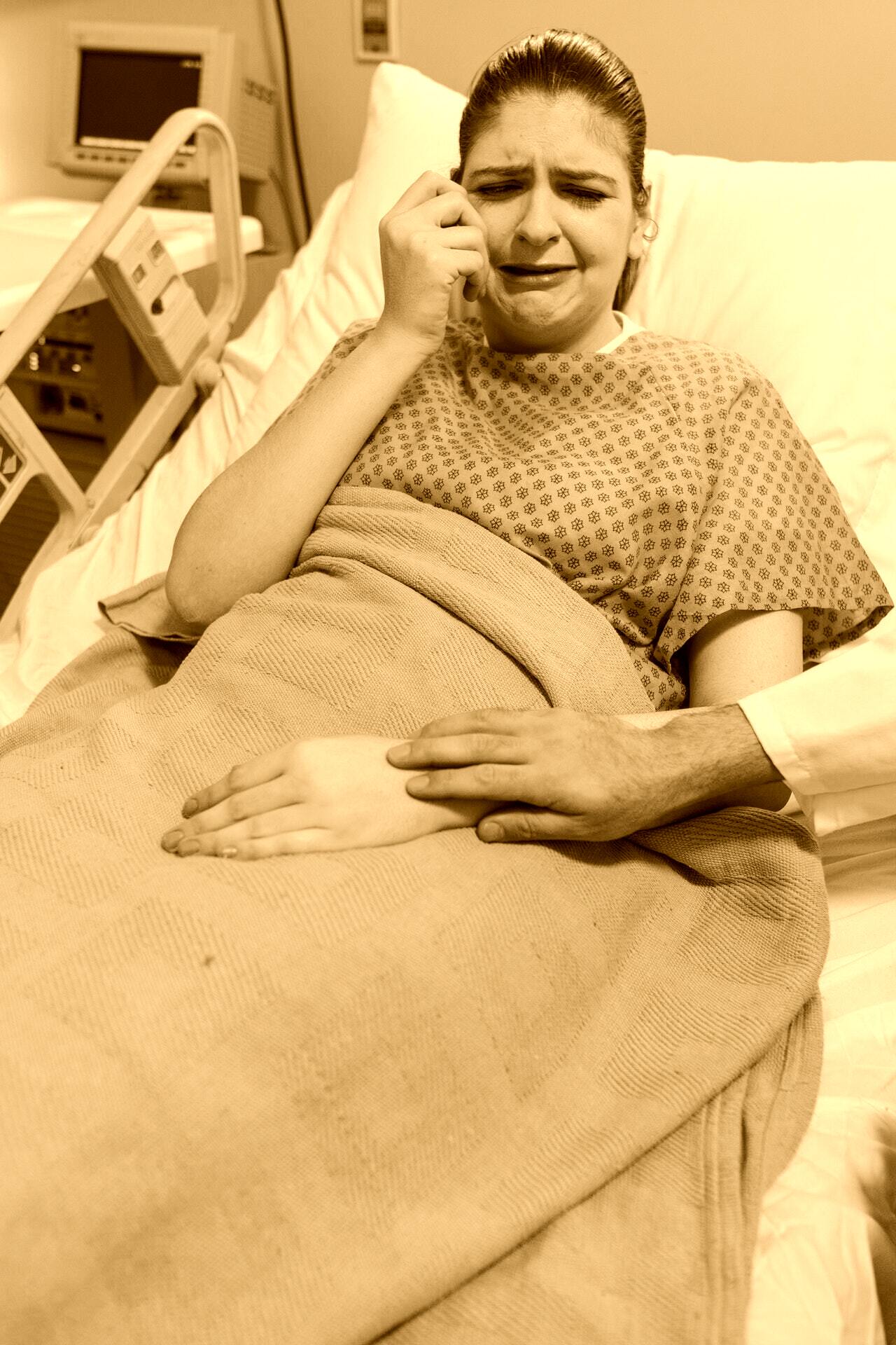 Una mujer llora en una cama de hospital. | Foto: Pexels