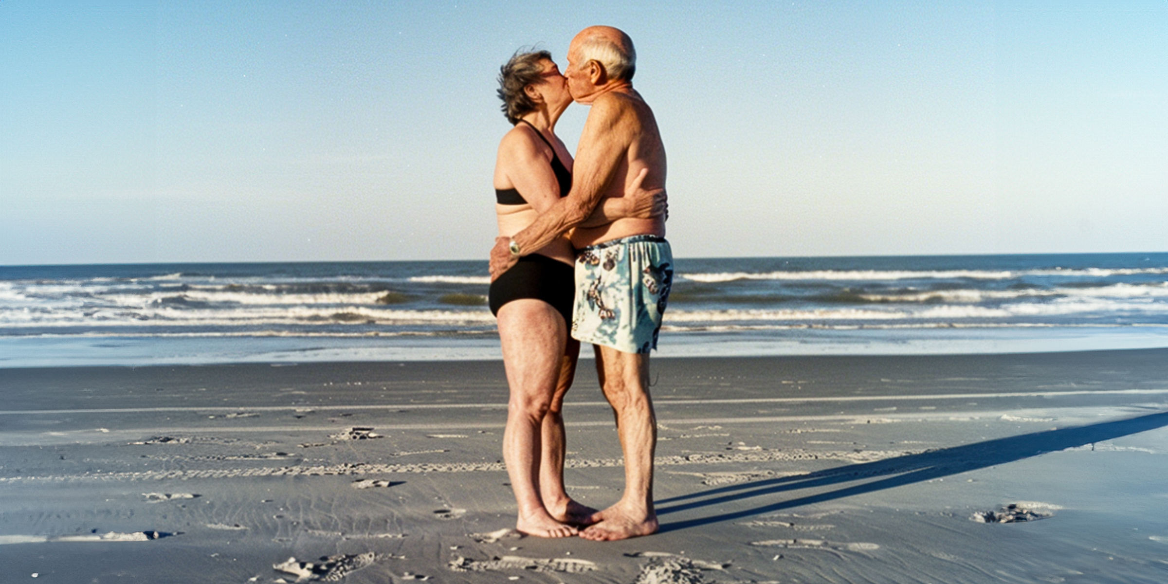 Una pareja mayor besándose en la playa | Fuente: AmoMama