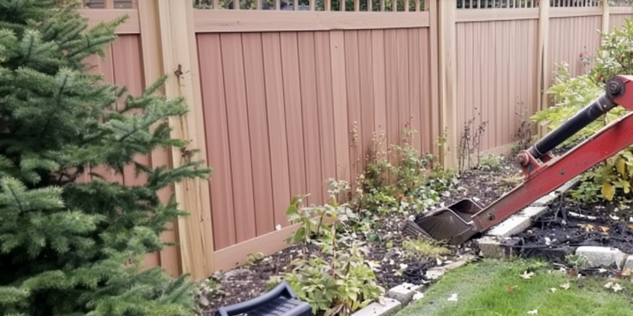 Una máquina trabajando en un jardín cerca de una valla de madera | Fuente: AmoMama