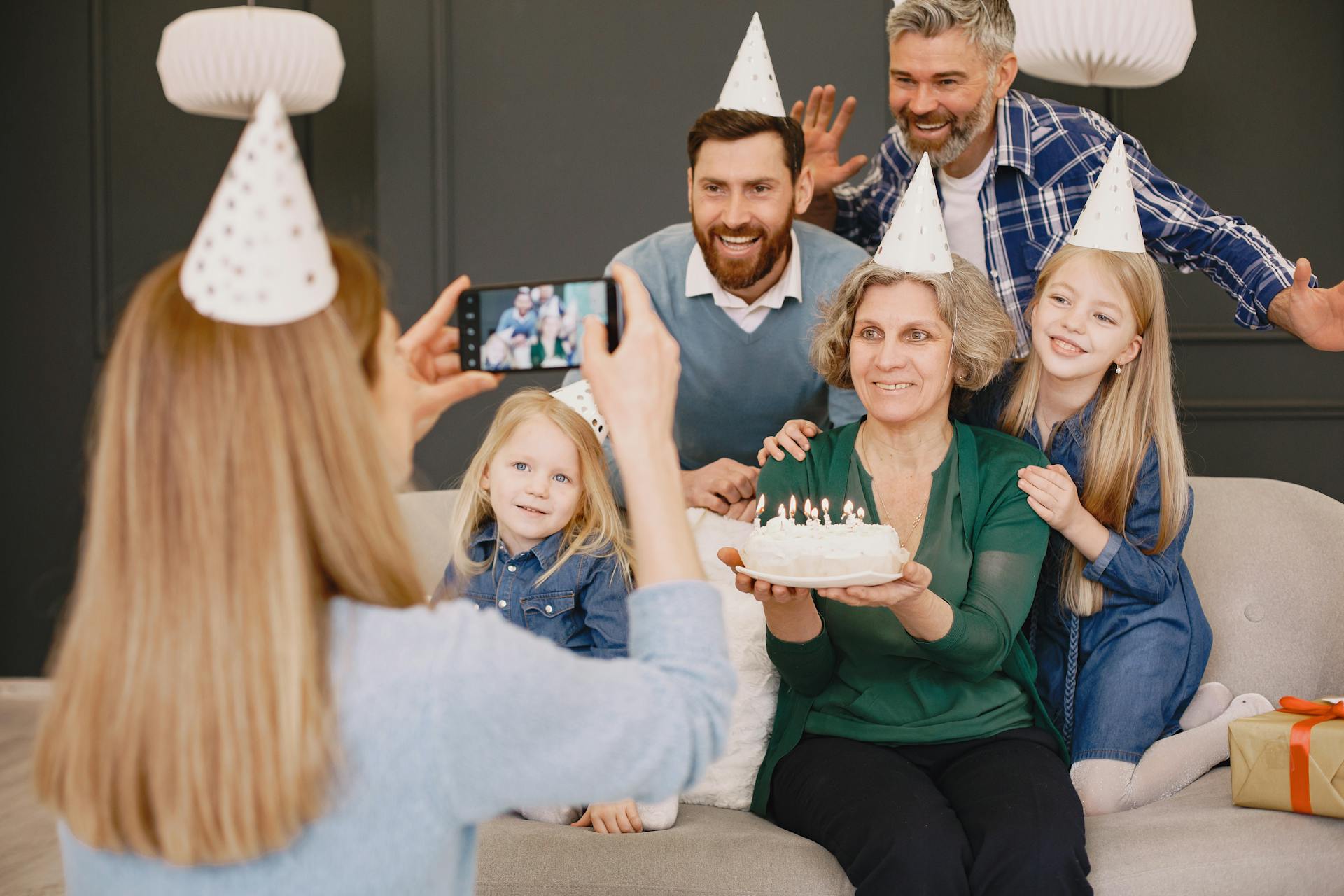 Una mujer fotografiando a su familia en la celebración de un cumpleaños | Fuente: Pexels