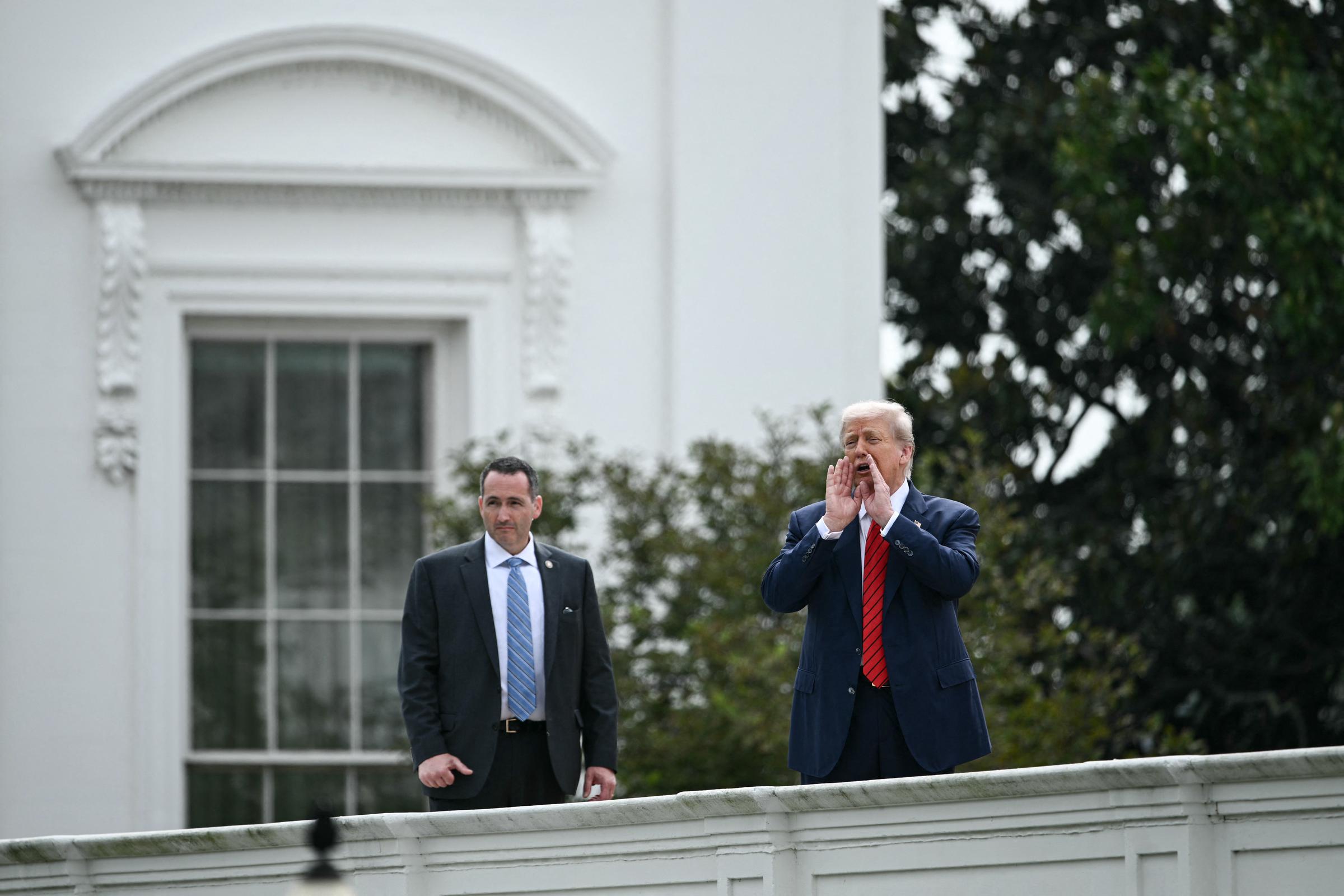 Con su equipo de seguridad cerca, el presidente Donald Trump le habla a la prensa desde el techo del ala oeste de la Casa Blanca en Washington, D.C., el 5 de agosto.
