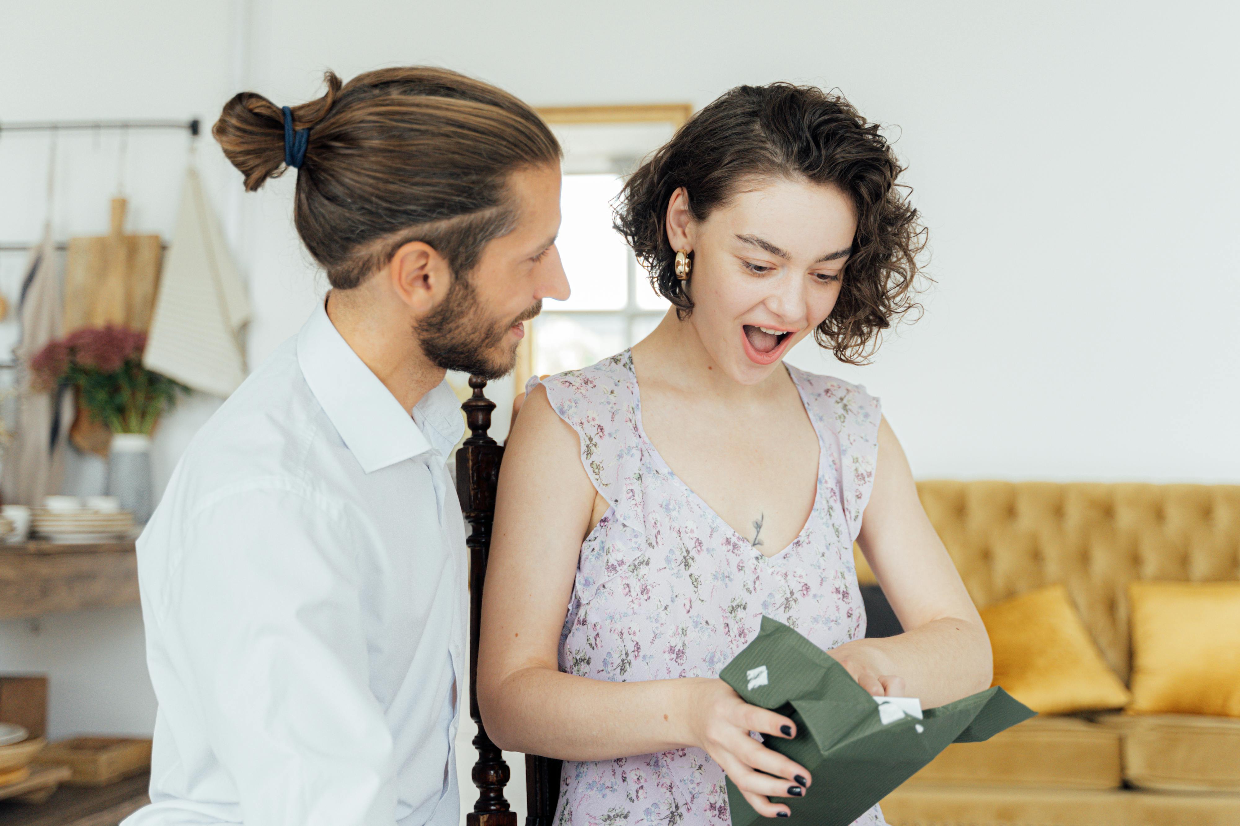 Una mujer reacciona sorprendida ante un regalo de un hombre | Fuente: Pexels