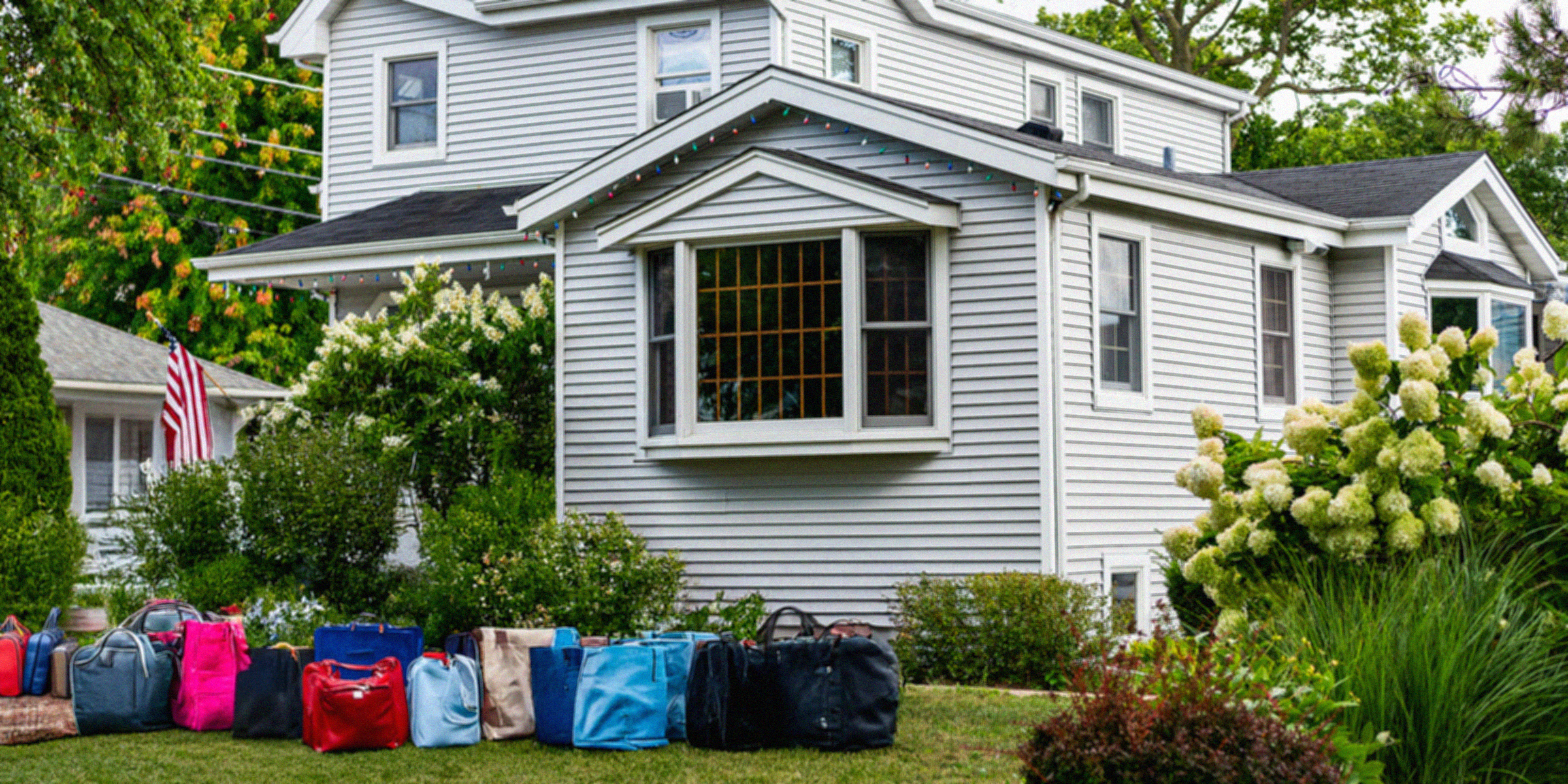 Bolsos y maletas delante de una casa suburbana ⏐ Fuente: Shutterstock