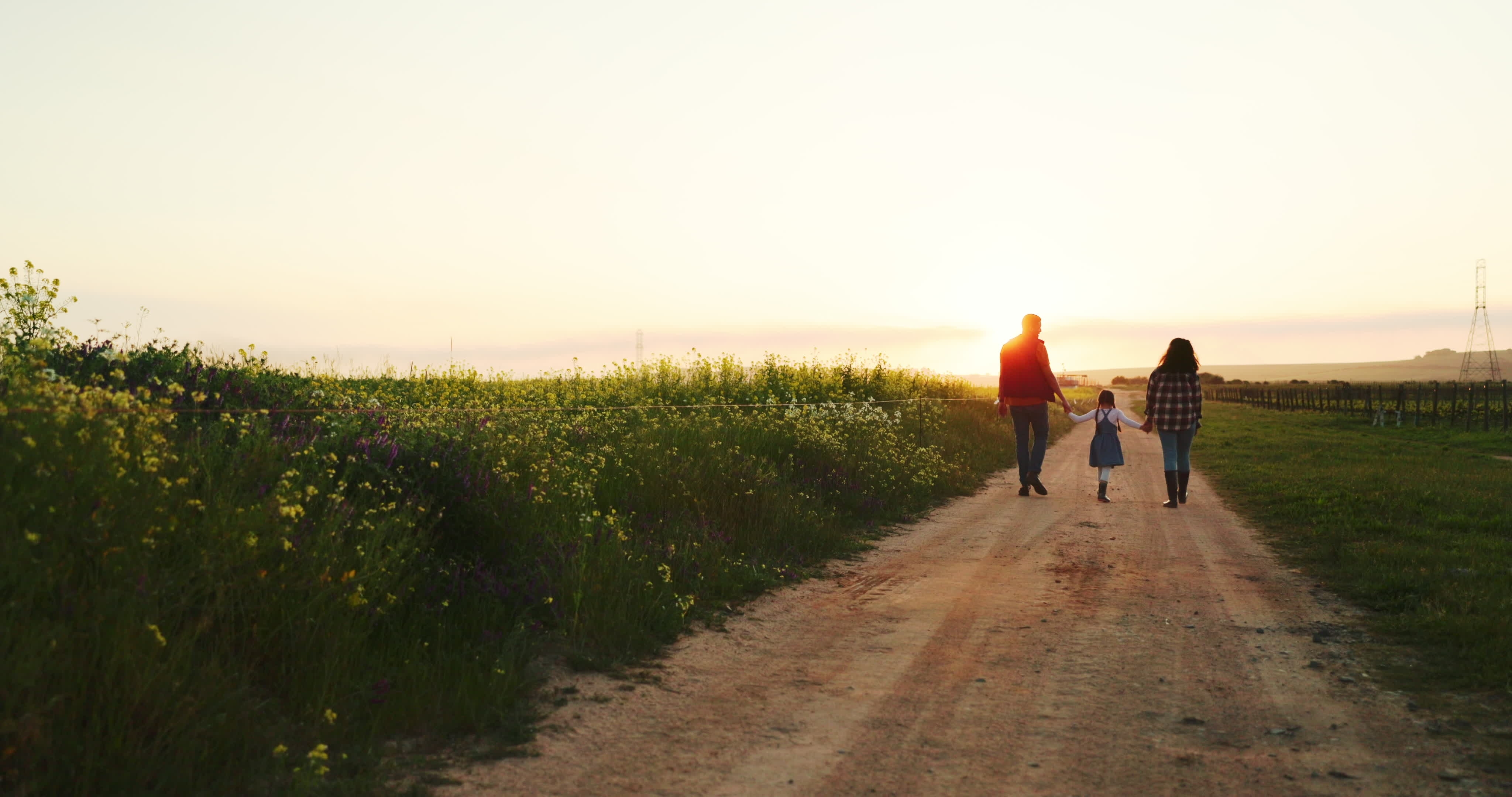 Una familia de tres miembros disfrutando de un paseo por su granja | Fuente: Shutterstock