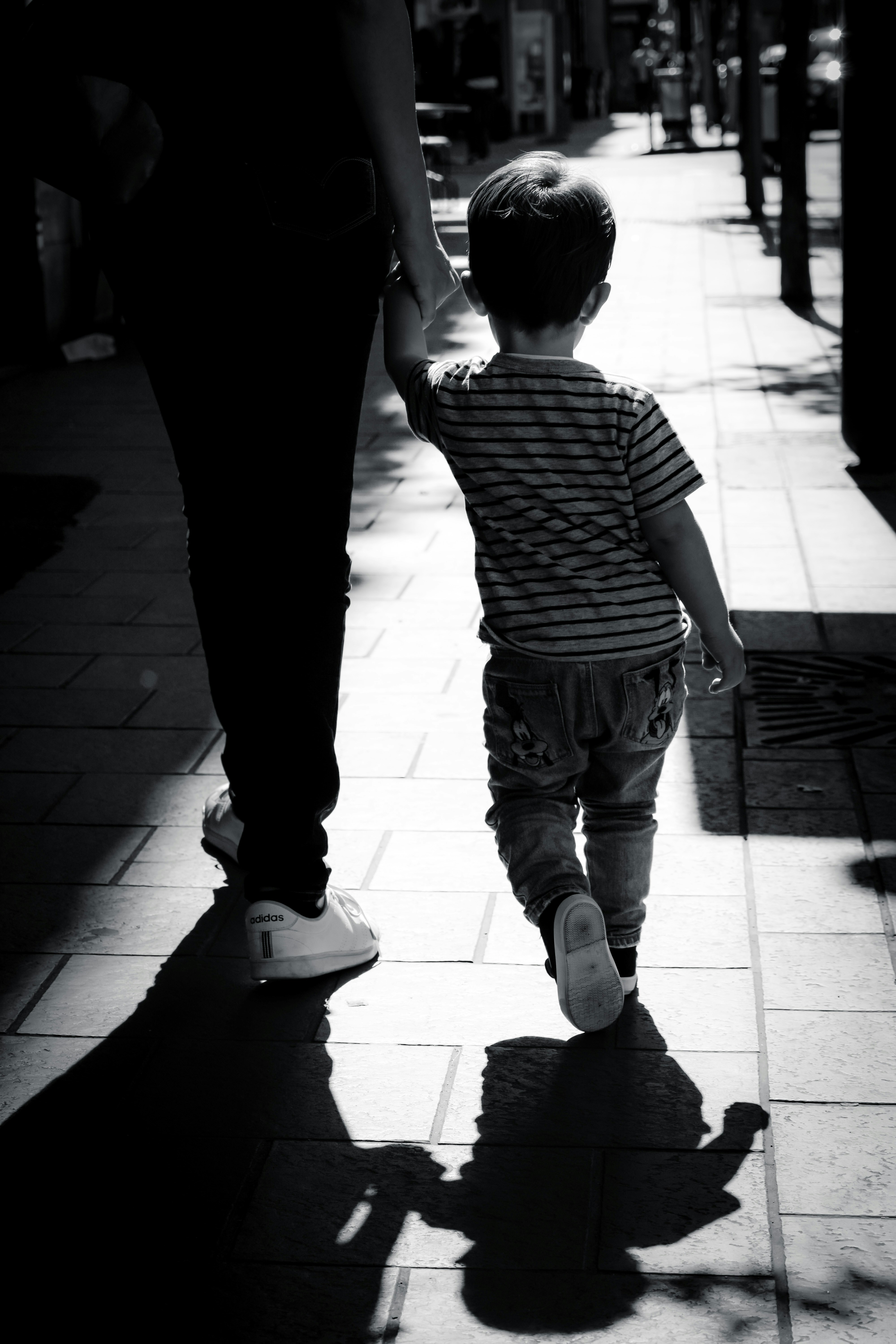 Una donna che cammina con un bambino | Fonte: Unsplash