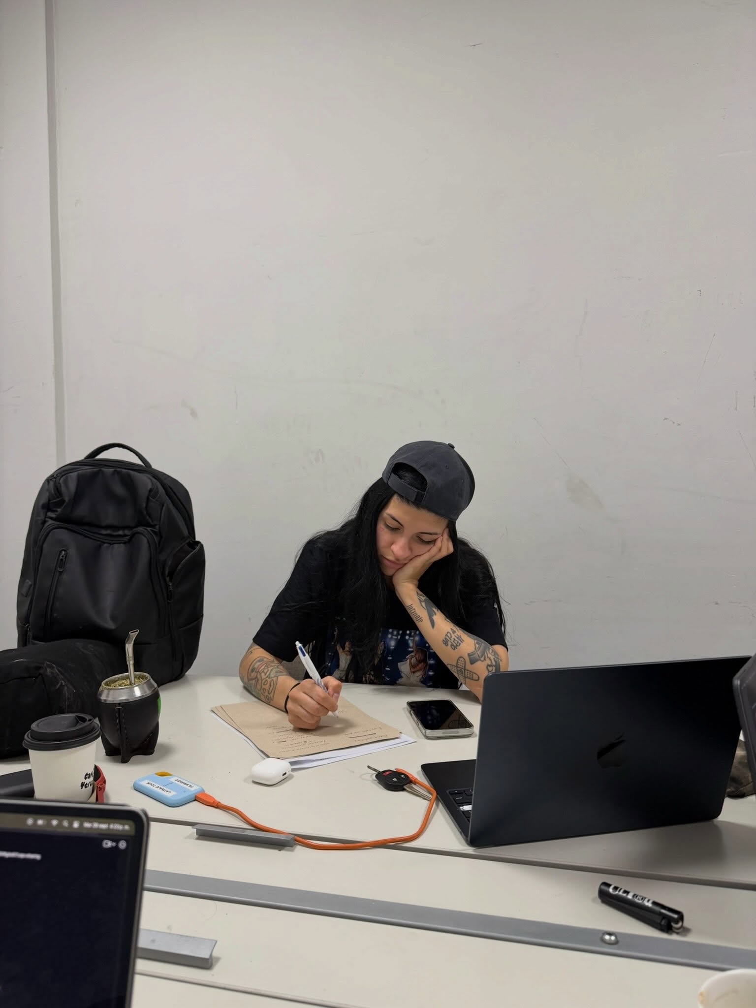 Cazzu sentada frente a un escritorio durante sus ensayos | Fuente: Instagram/cazzu