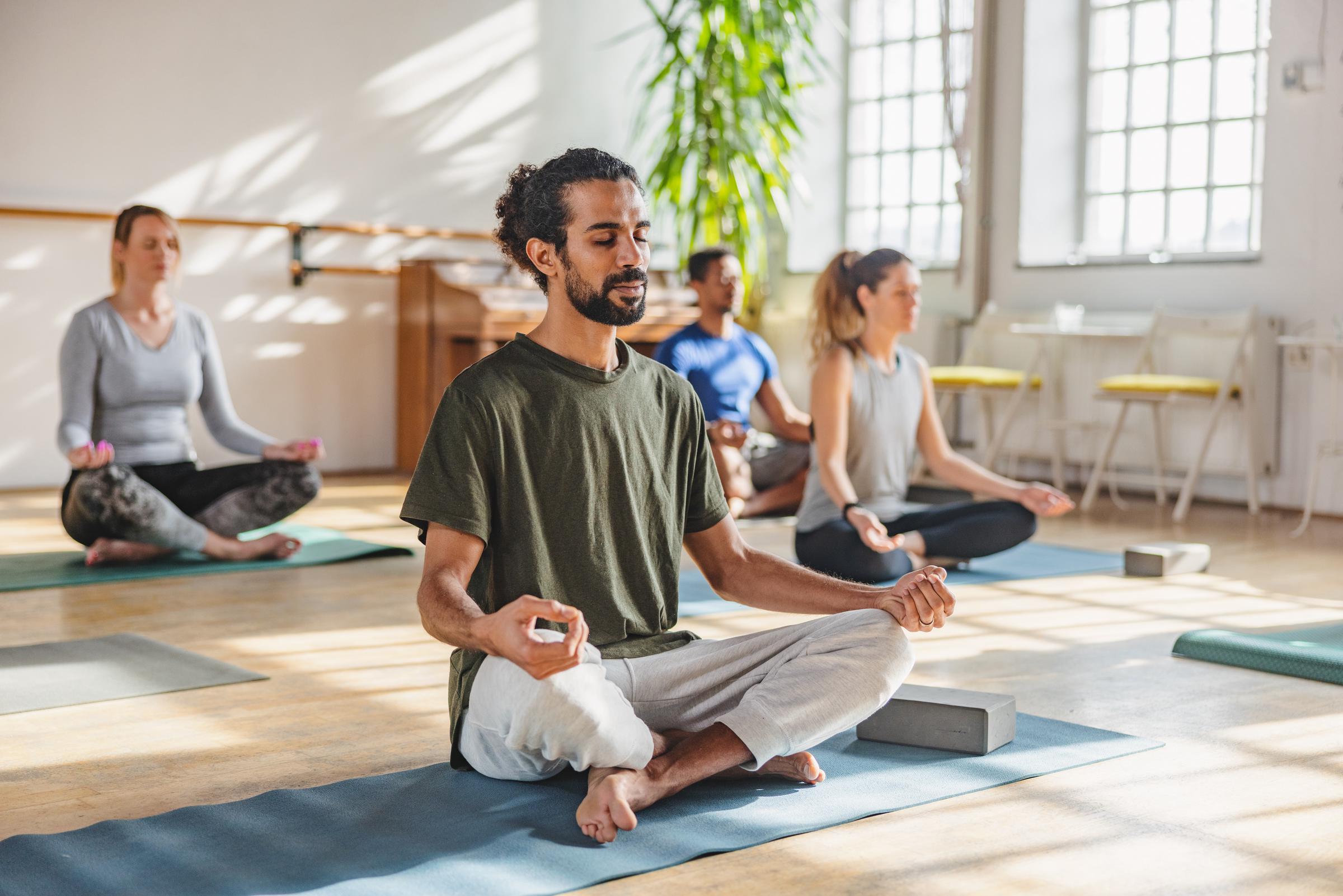 Un grupo de personas haciendo yoga en un estudio | Fuente: Getty Images