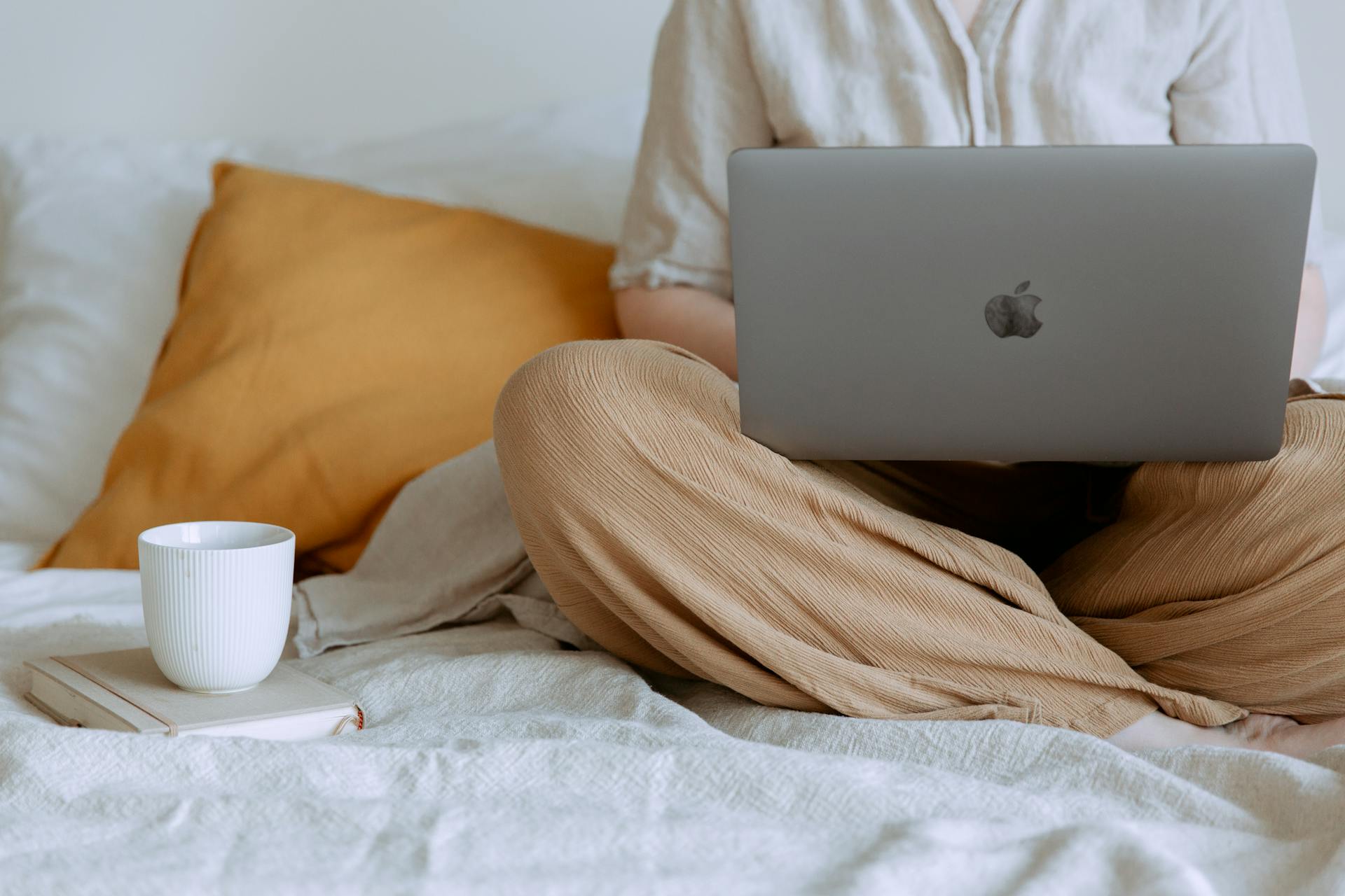 Mujer usando un portátil en su dormitorio | Fuente: Pexels