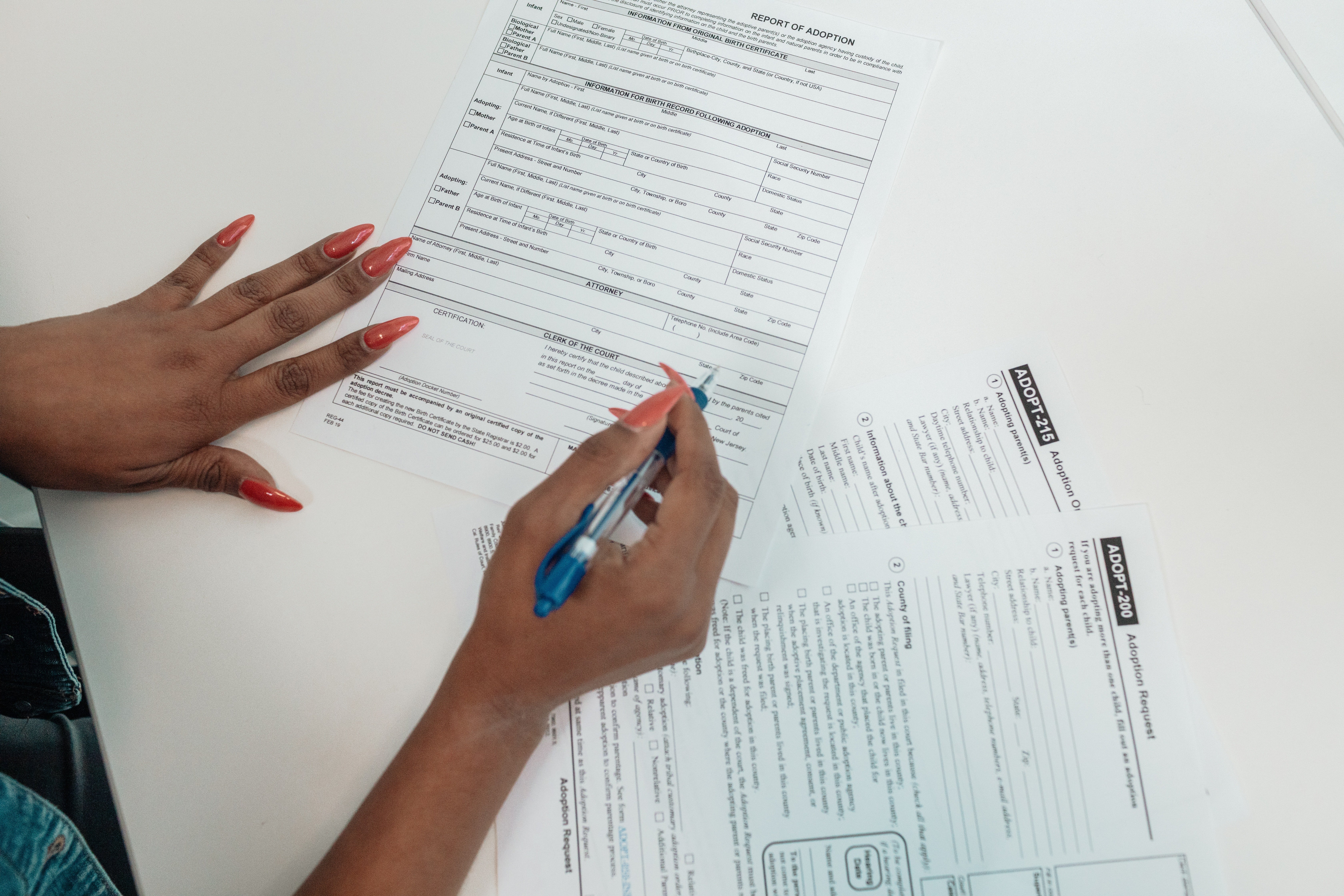 Mano femenina rellena formularios de adopción. | Foto: Pexels