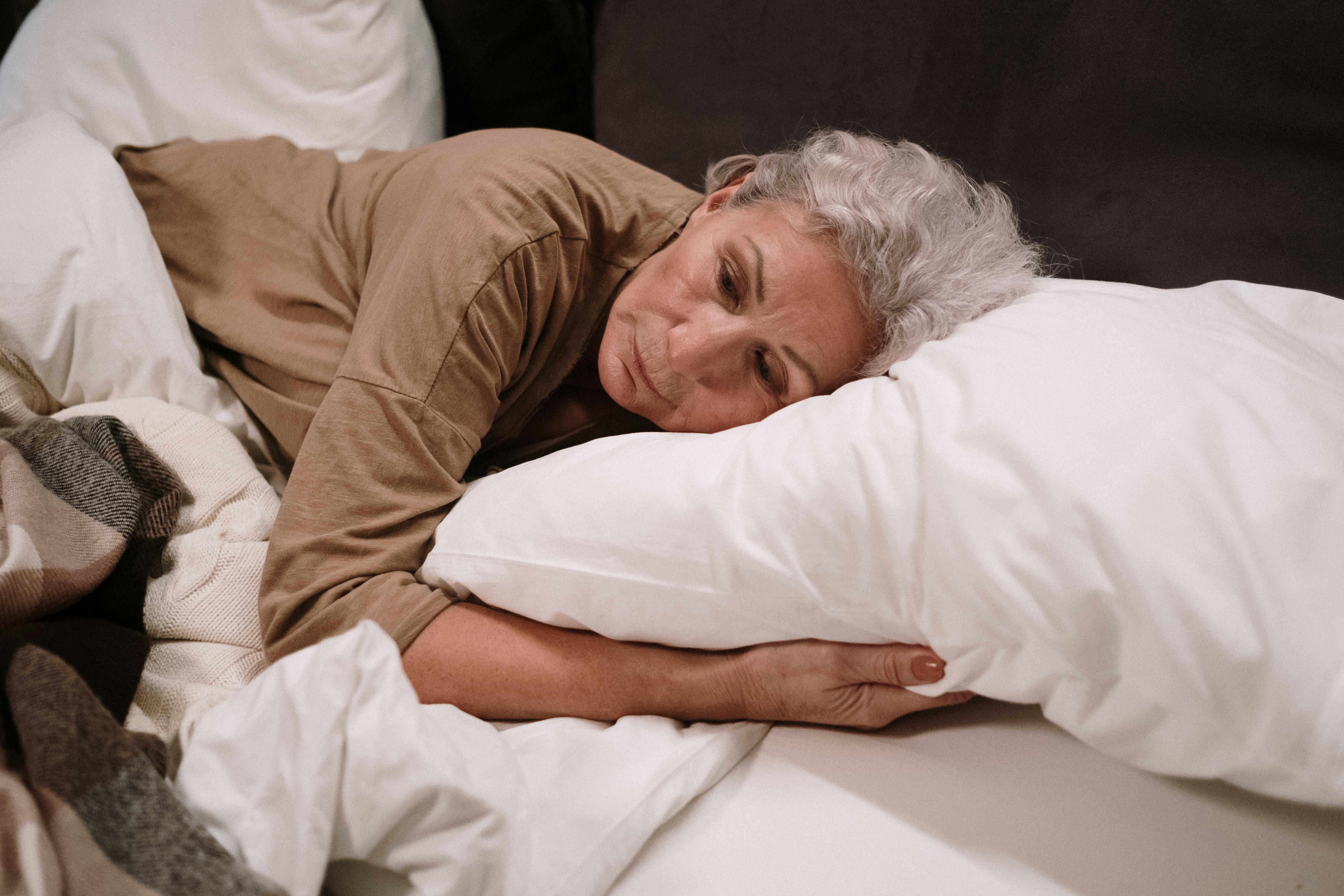 Mujer triste en su cama | Foto: Pexels