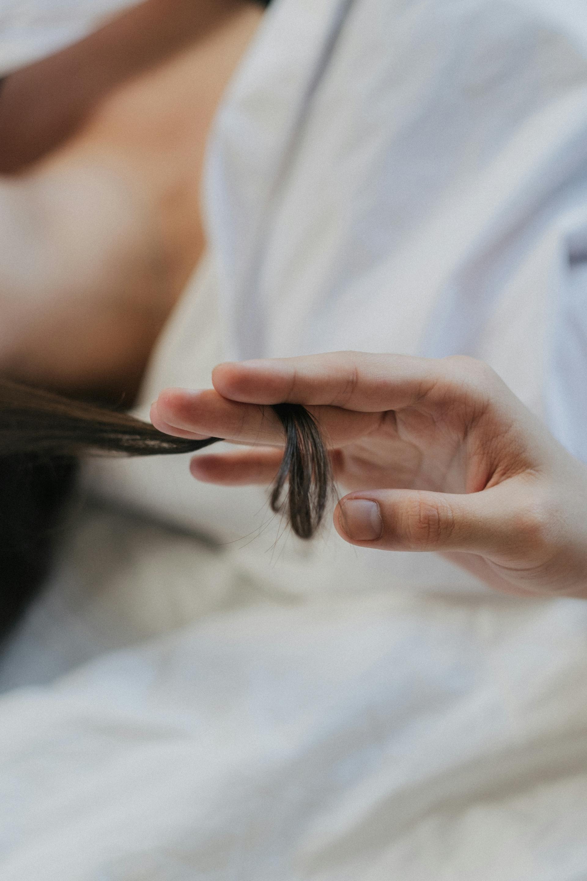 Una persona haciendo girar un mechón de pelo | Foto: Pexels