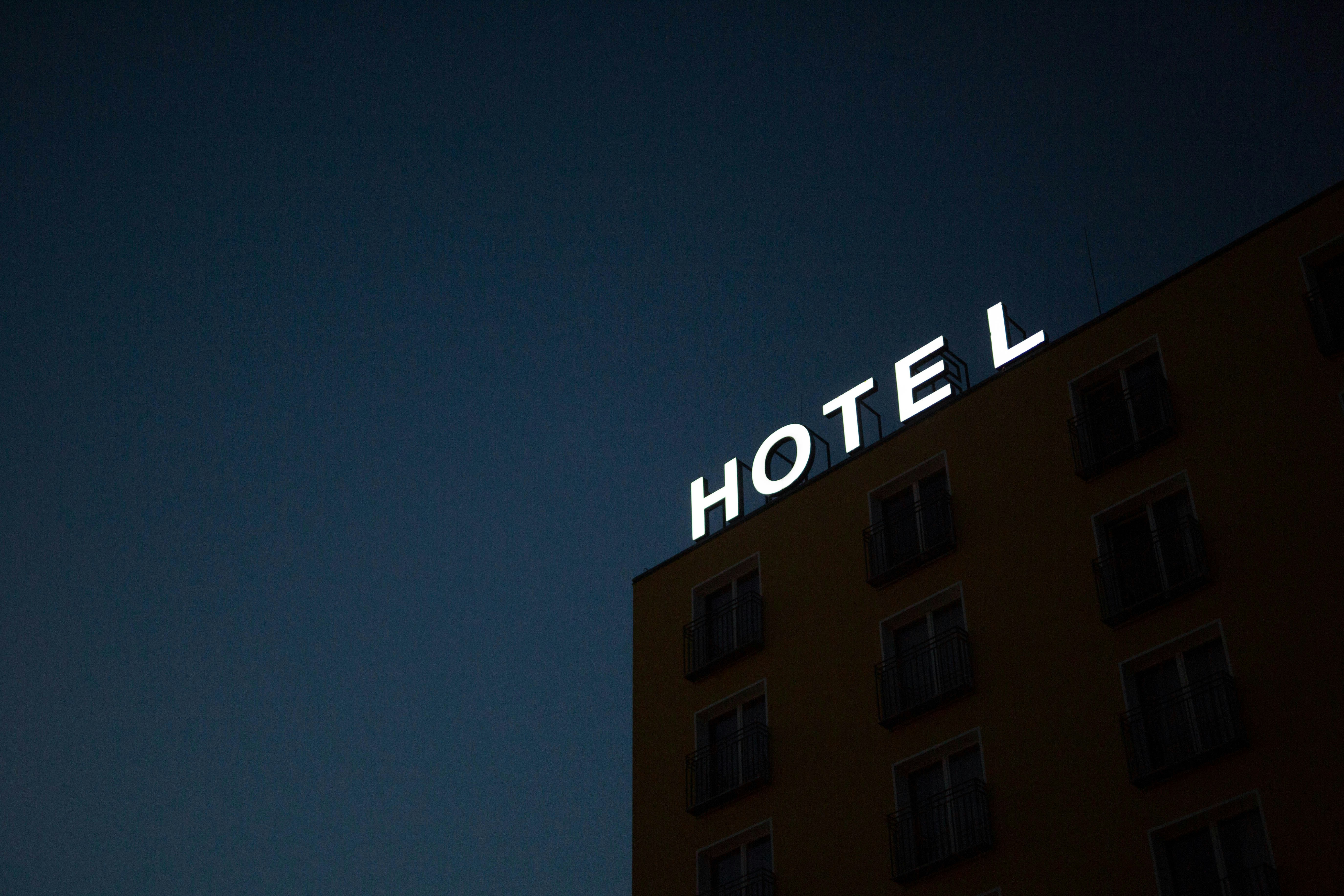 Un letrero de neón que dice "HOTEL" en lo alto de un edificio | Fuente: Unsplash