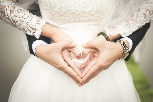 Recién casados con manos entrelazadas. Fuente: Pixabay