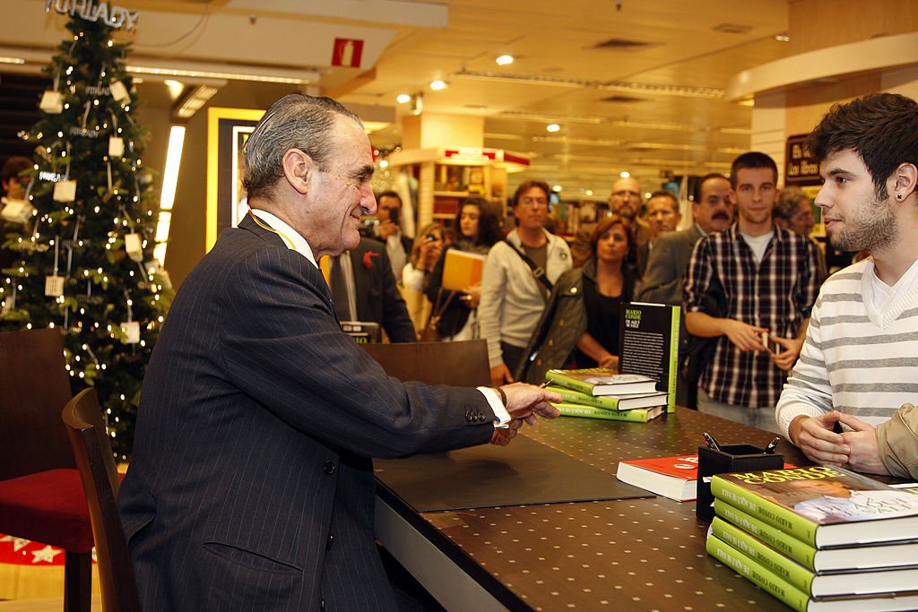 Mario Conde saluda a un fan mientras le firma un autógrafo.| Fuente: Getty Images