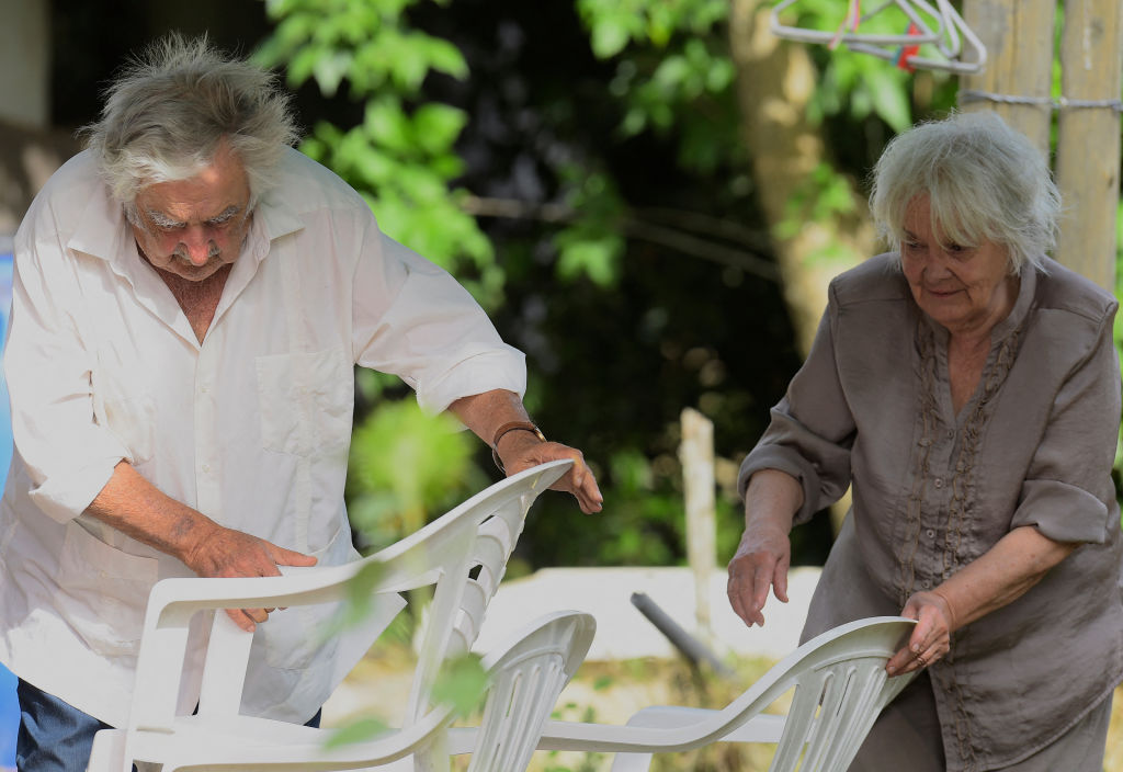 José Mujica (izq.) y su esposa Lucia Topolansky reciben al presidente brasileño Luiz Inácio Lula da Silva (fuera de cuadro) en su chacra en Rincón del Cerro, Montevideo, el 25 de enero de 2023, durante su visita a Uruguay. | Foto: Getty Images