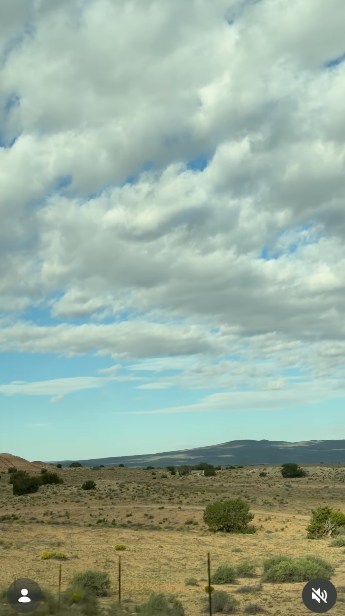 Una amplia vista del desierto captada bajo unas nubes cúmulos que se extienden por el cielo y un cielo azul pálido durante un viaje por el suroeste el 11 de octubre de 2026. La baja vegetación árida, los toques de verde dispersos y las suaves siluetas de las montañas definen este terreno sereno y abierto. | Fuente: Instagram/selmablair