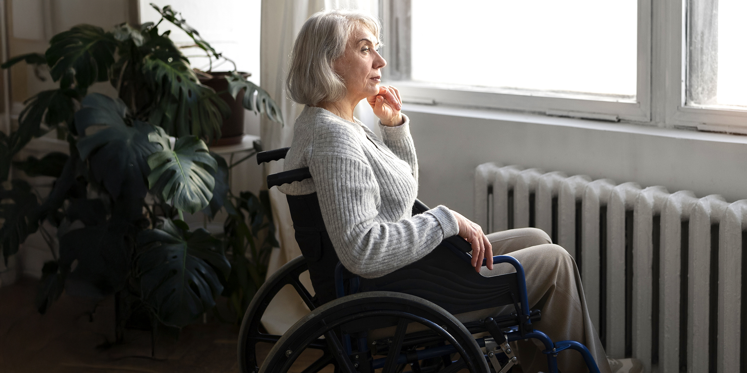 Una anciana mirando por la ventana | Fuente: Freepik