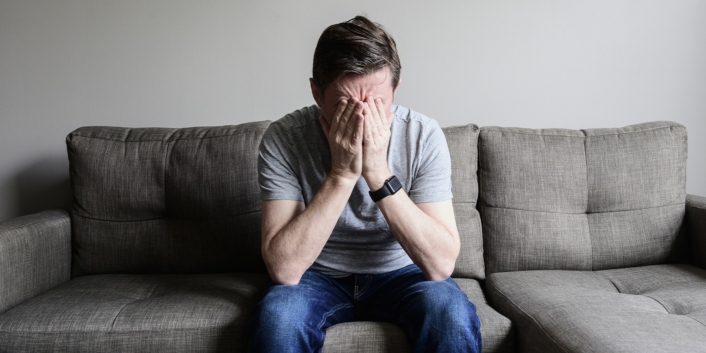 Hombre disgustado sentado en un sofá | Fuente: Getty images