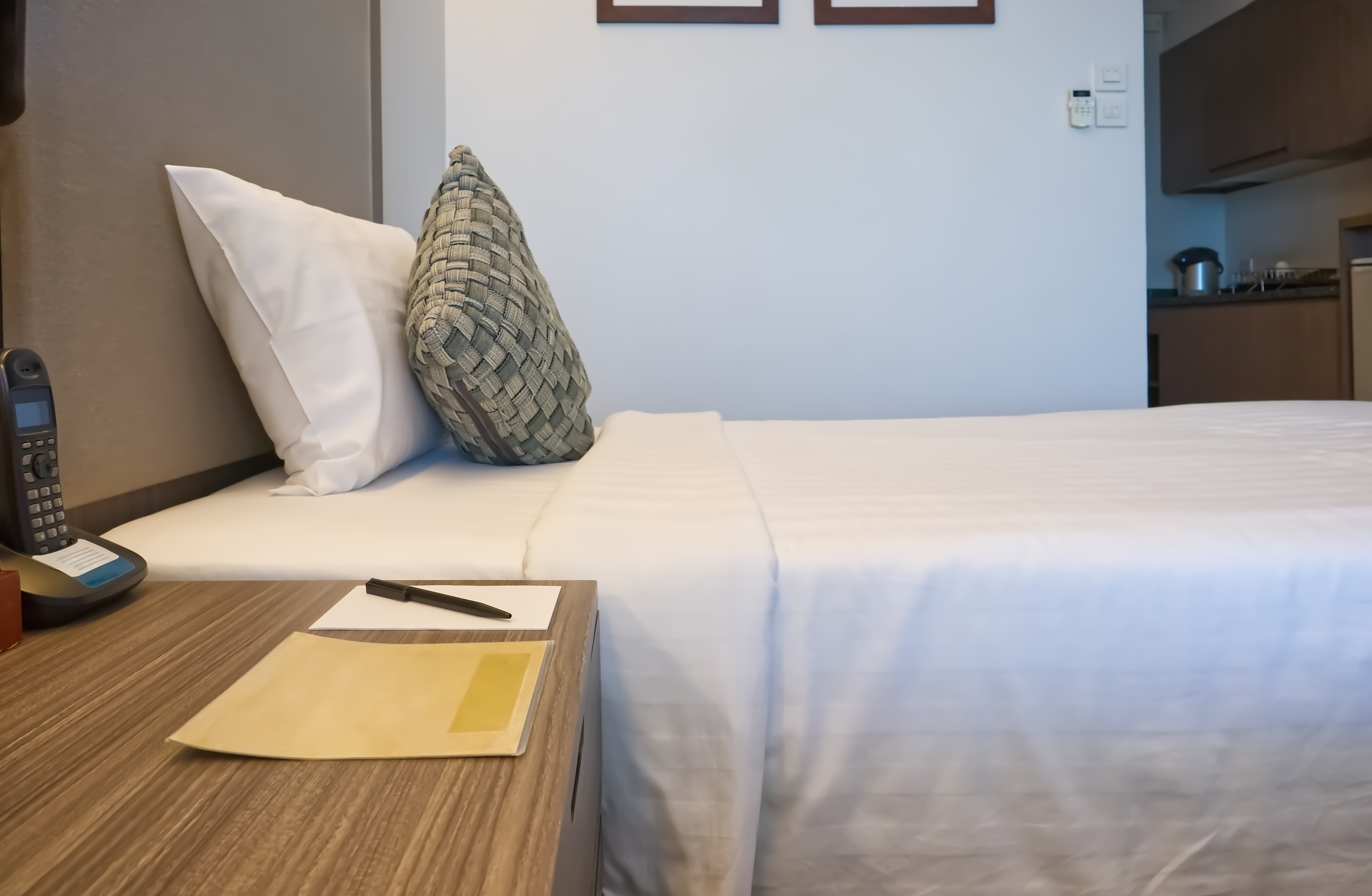 Un bloc de notas y un bolígrafo junto a una cama | Foto: Shutterstock
