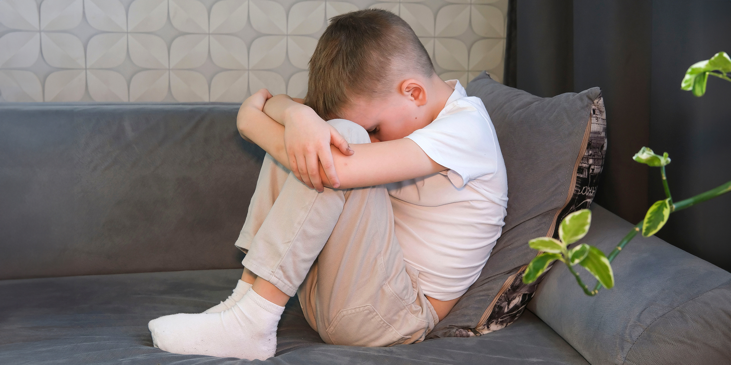 Un niño enfadado sentado en un sofá | Fuente: Shutterstock