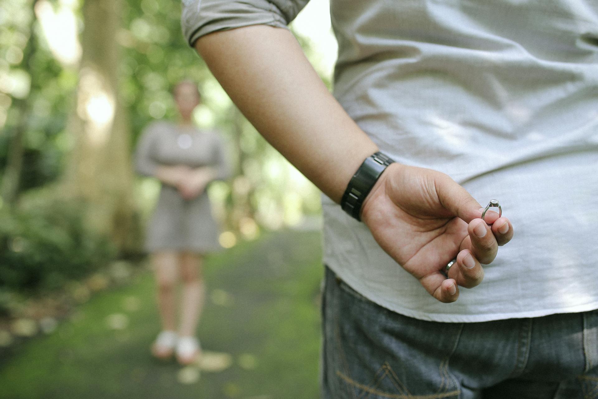 Un hombre esconde un anillo de compromiso a sus espaldas | Fuente: Pexels
