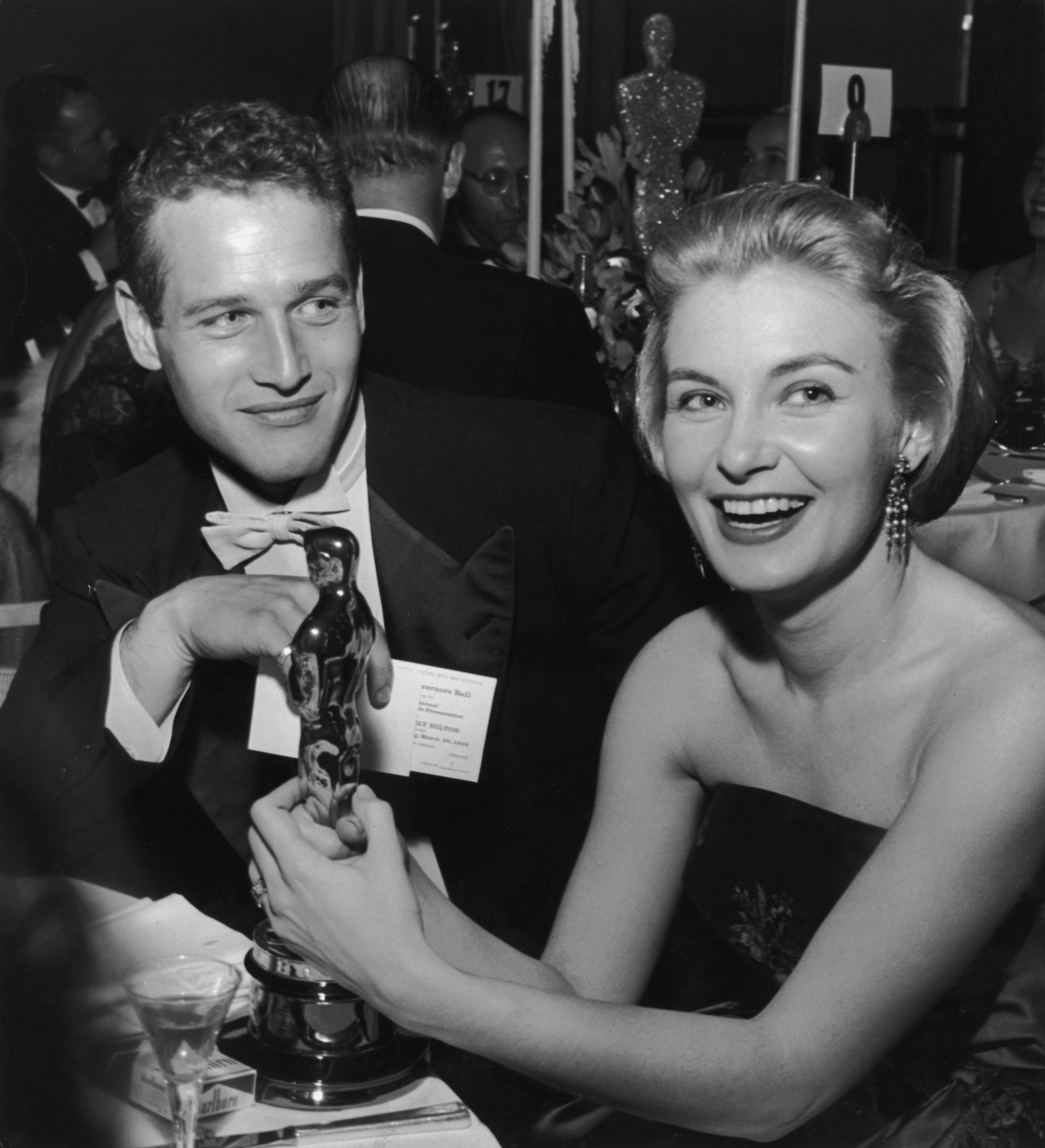 Joanne Woodward sostiene su Oscar por "The Three Faces of Eve" junto a Paul Newman, durante una fiesta de los Oscar en 1958 | Fuente: Getty Images