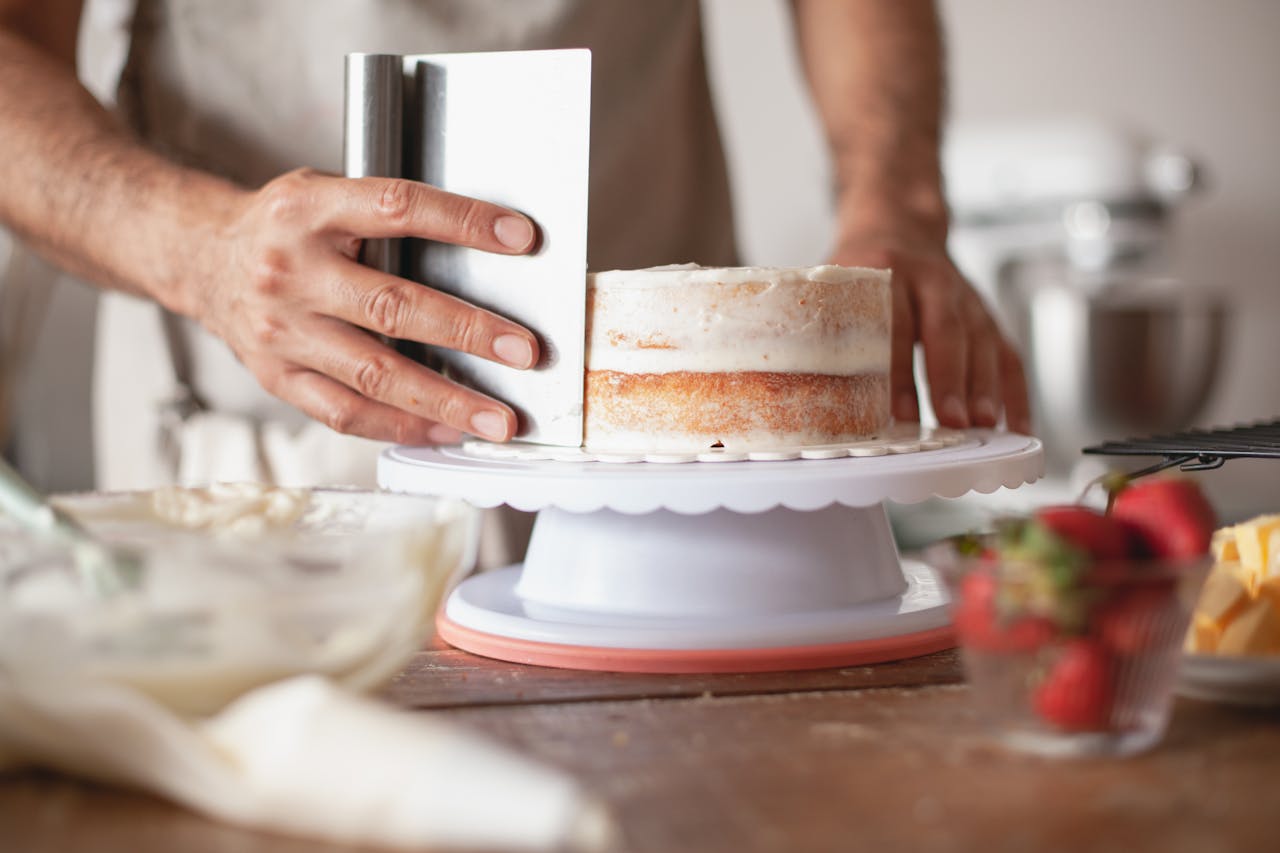 Hombre decorando un pastel | Fuente: Pexels