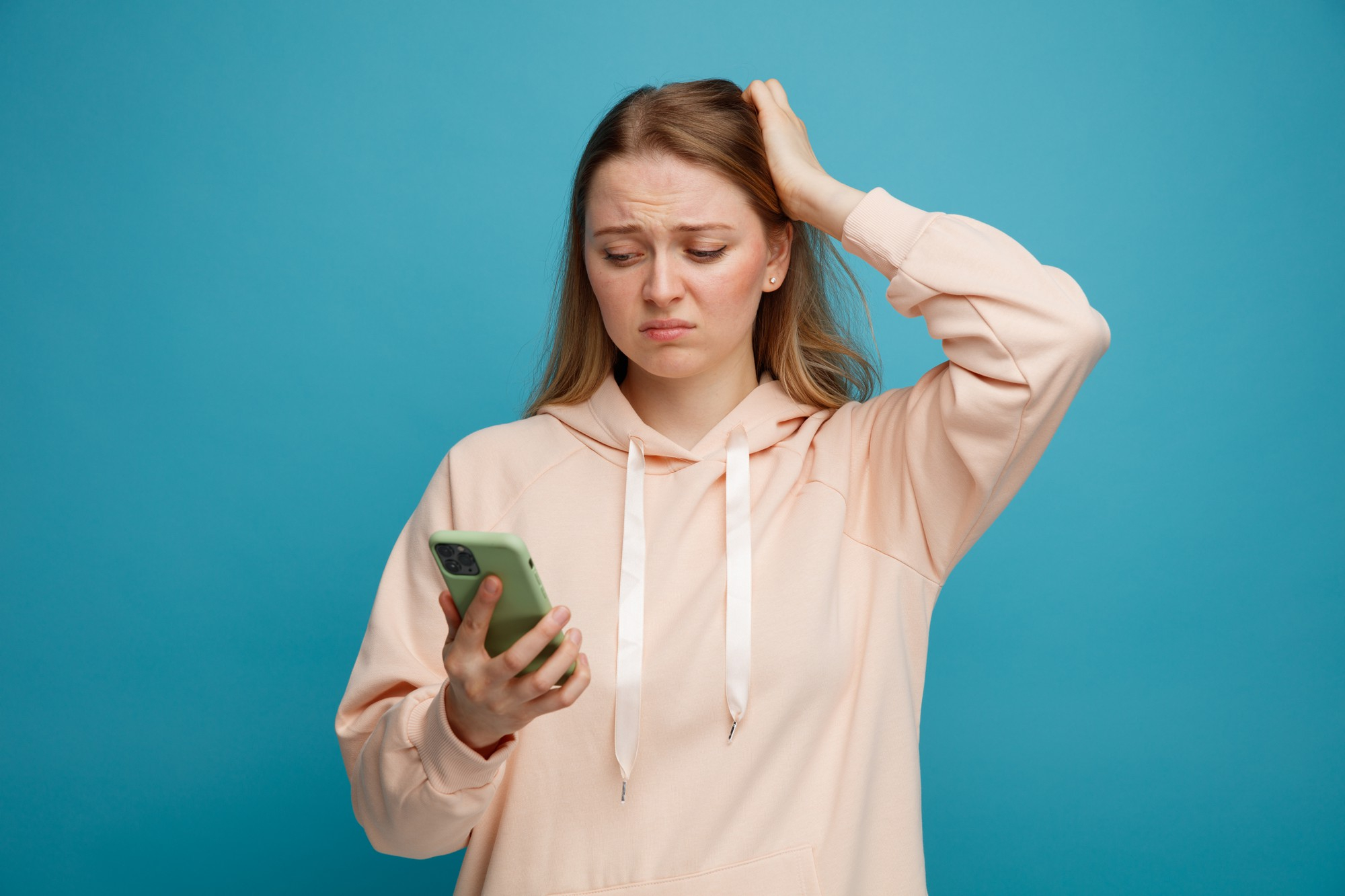 Una mujer alterada mirando su teléfono y sujetándose la cabeza | Foto: Freepiks