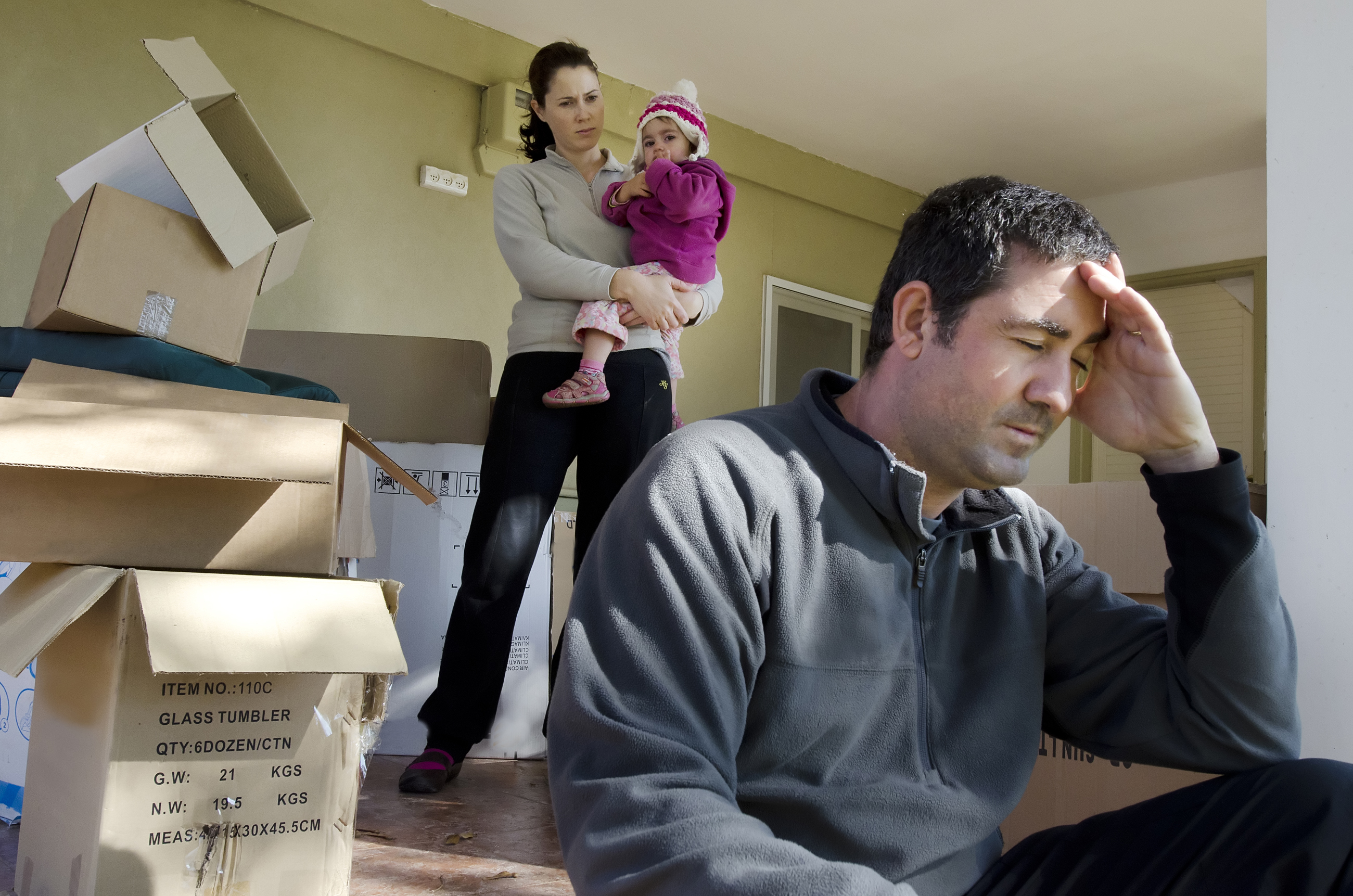 Un hombre con problemas con su mujer y su hijo detrás | Foto: Shutterstock