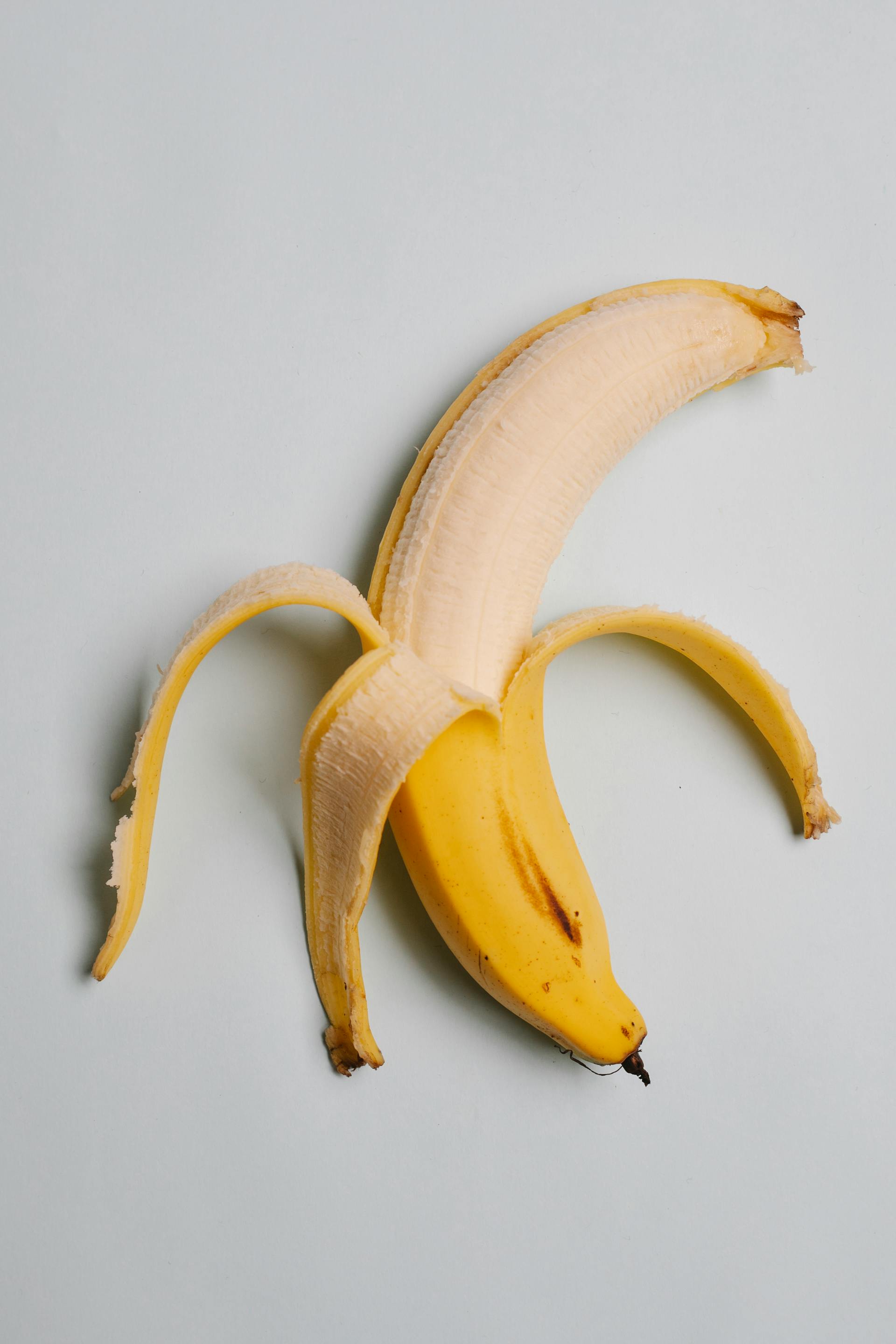 Un plátano parcialmente pelado | Fuente: Pexels