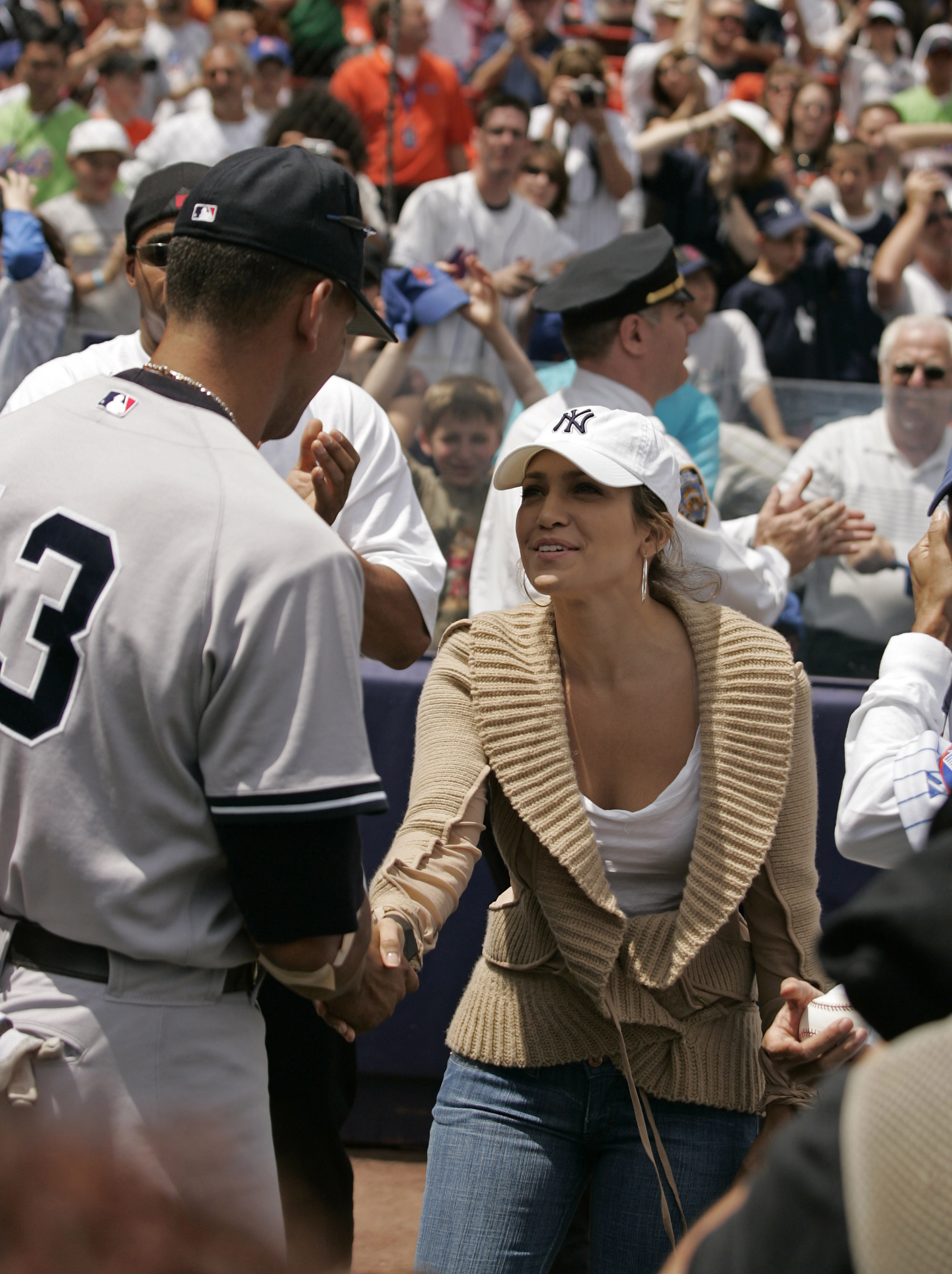 Jennifer Lopez estrecha la mano de Alex Rodriguez antes de un partido de la serie del metro en Queens, Nueva York, el 21 de mayo de 2005. | Foto: Getty Images