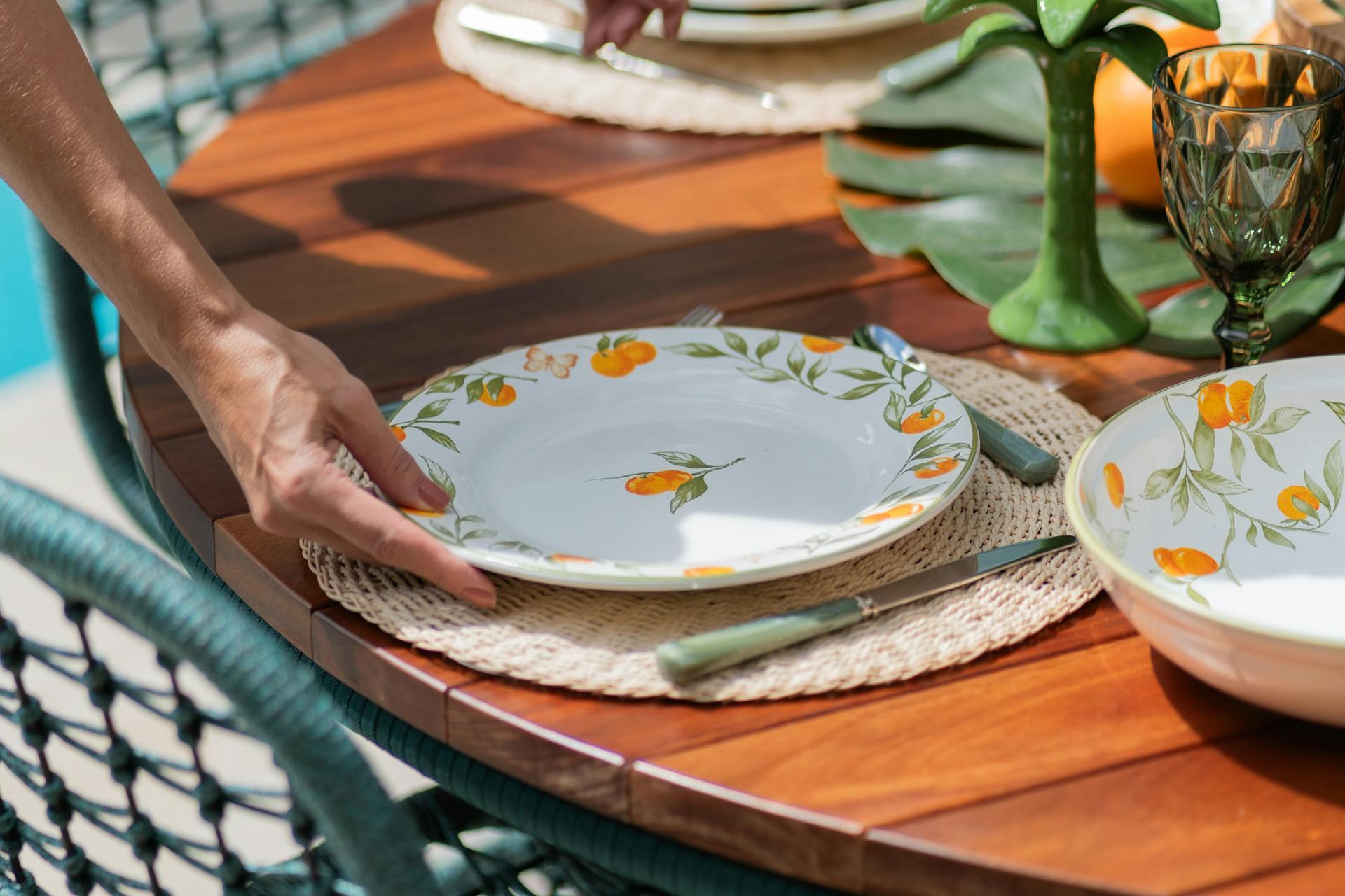 Una mujer poniendo un plato en una mesa | Fuente: Pexels