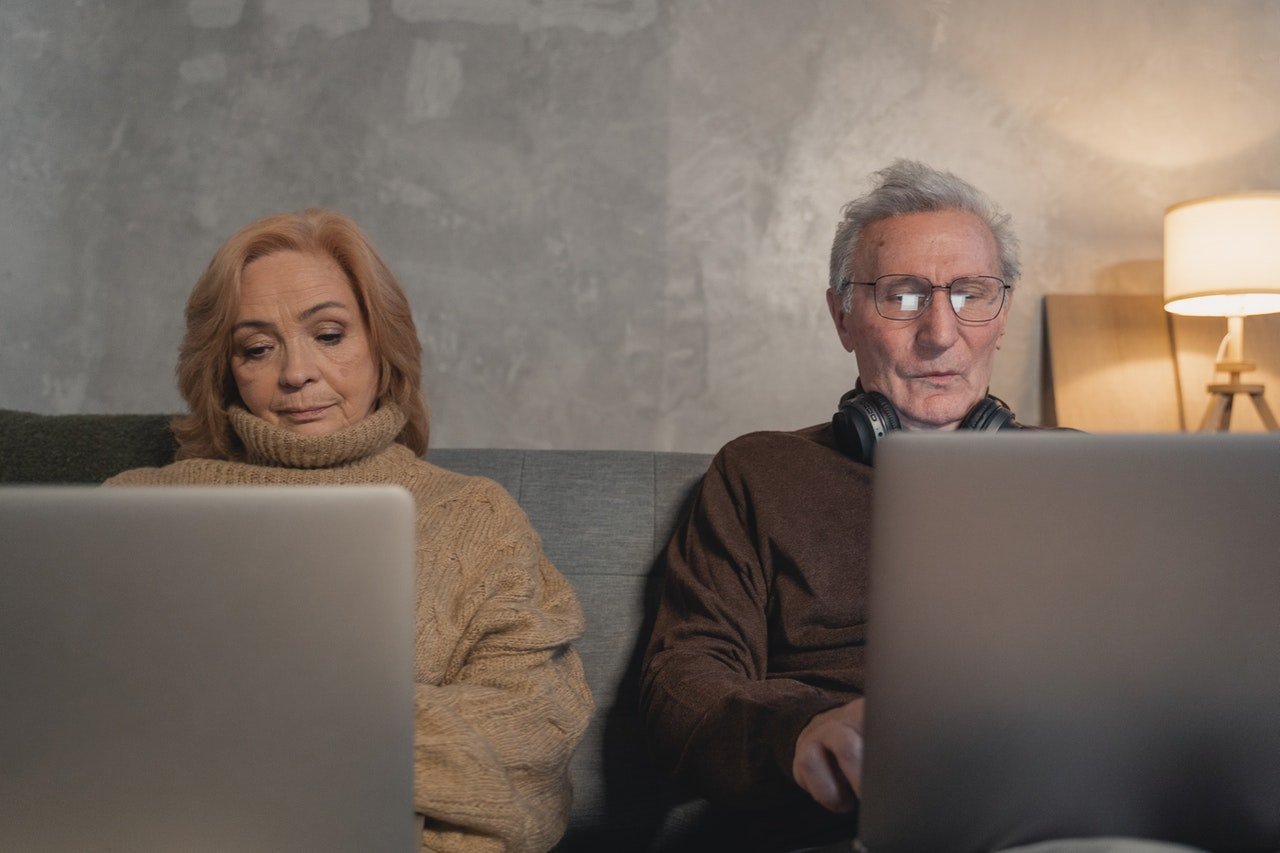 Pareja de adultos mayores viendo su computadora portátil. | Foto: Pexels