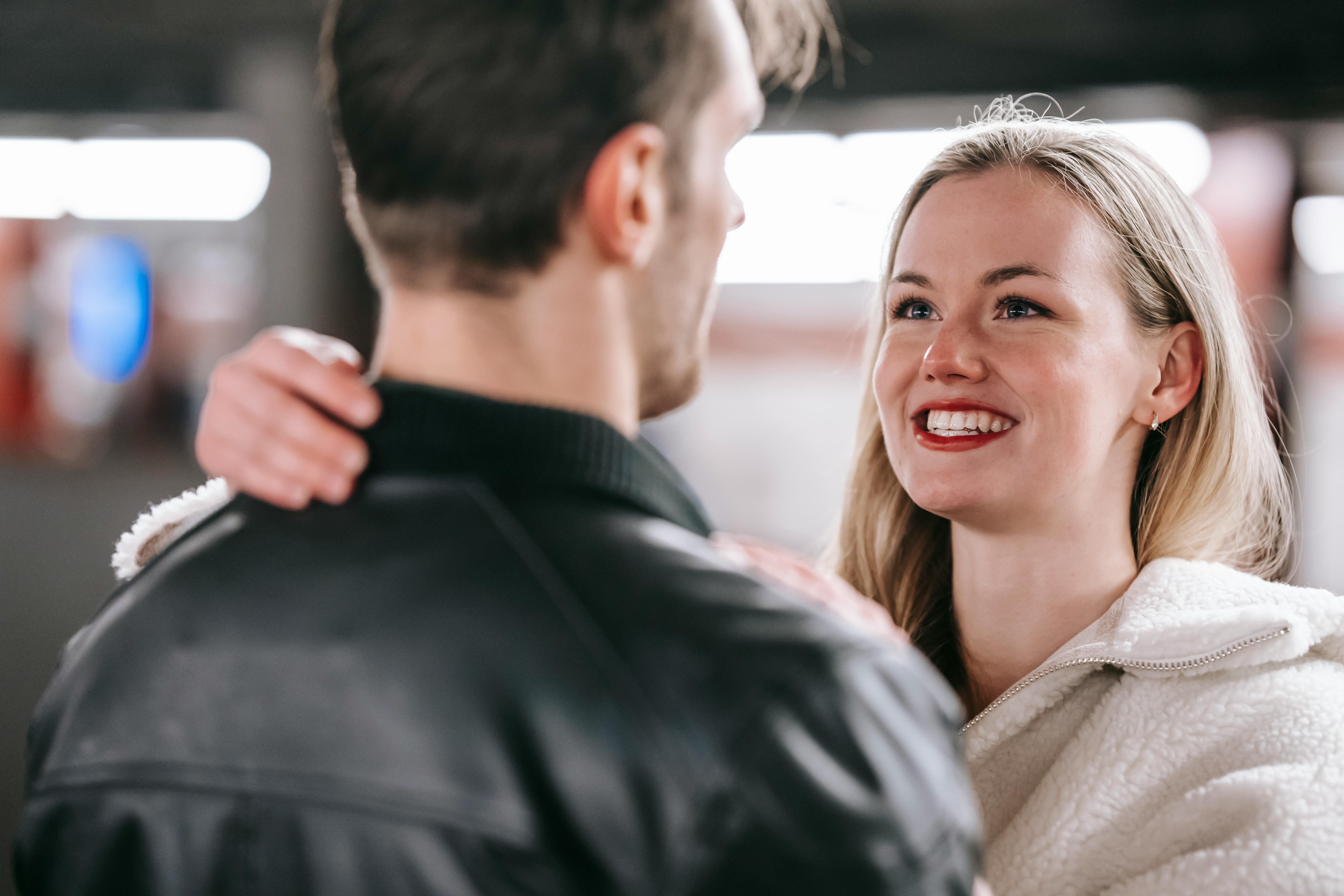 Una mujer sonriente frente a un hombre | Fuente: Pexels