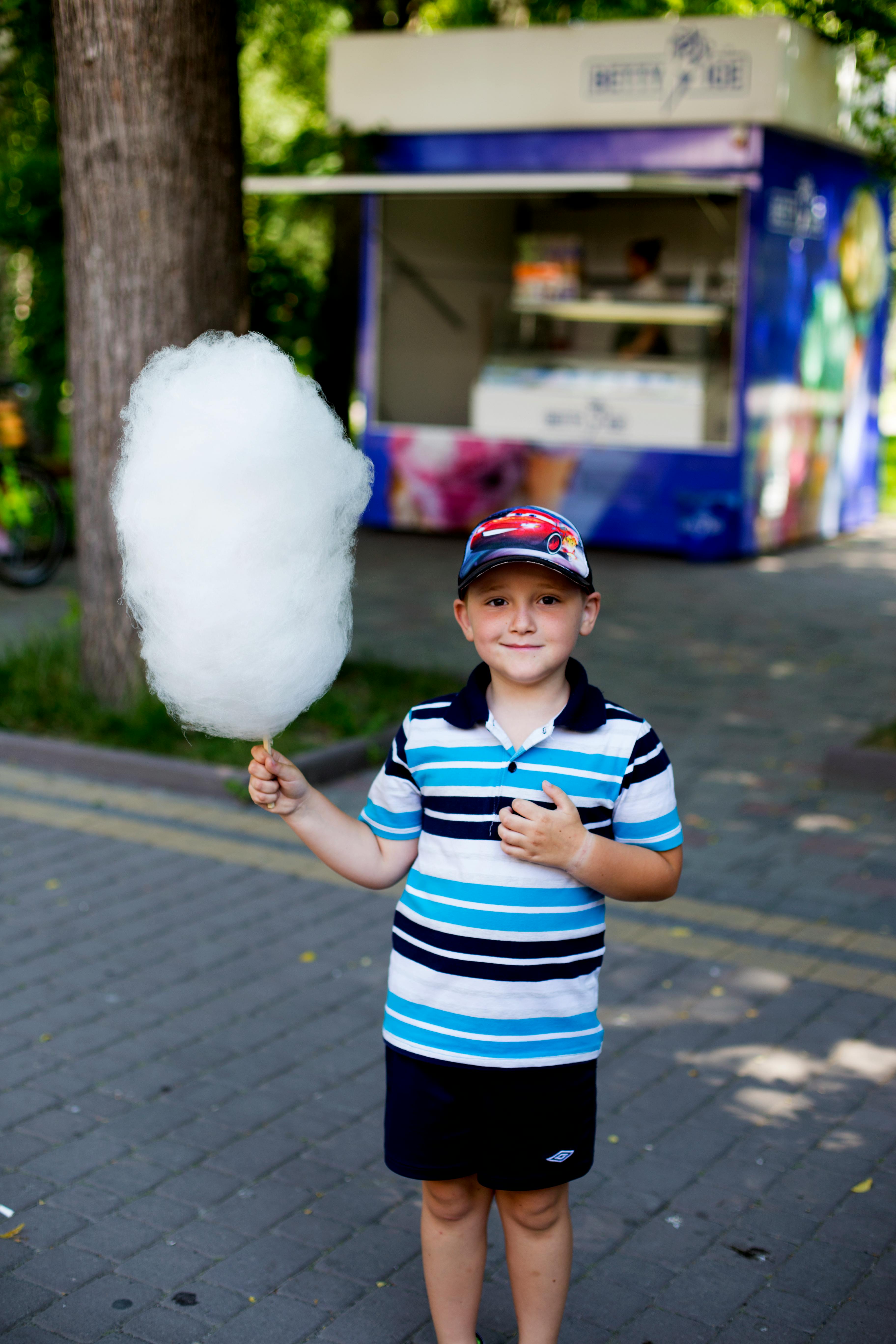 Un niño posando con algodón de azúcar | Fuente: Pexels