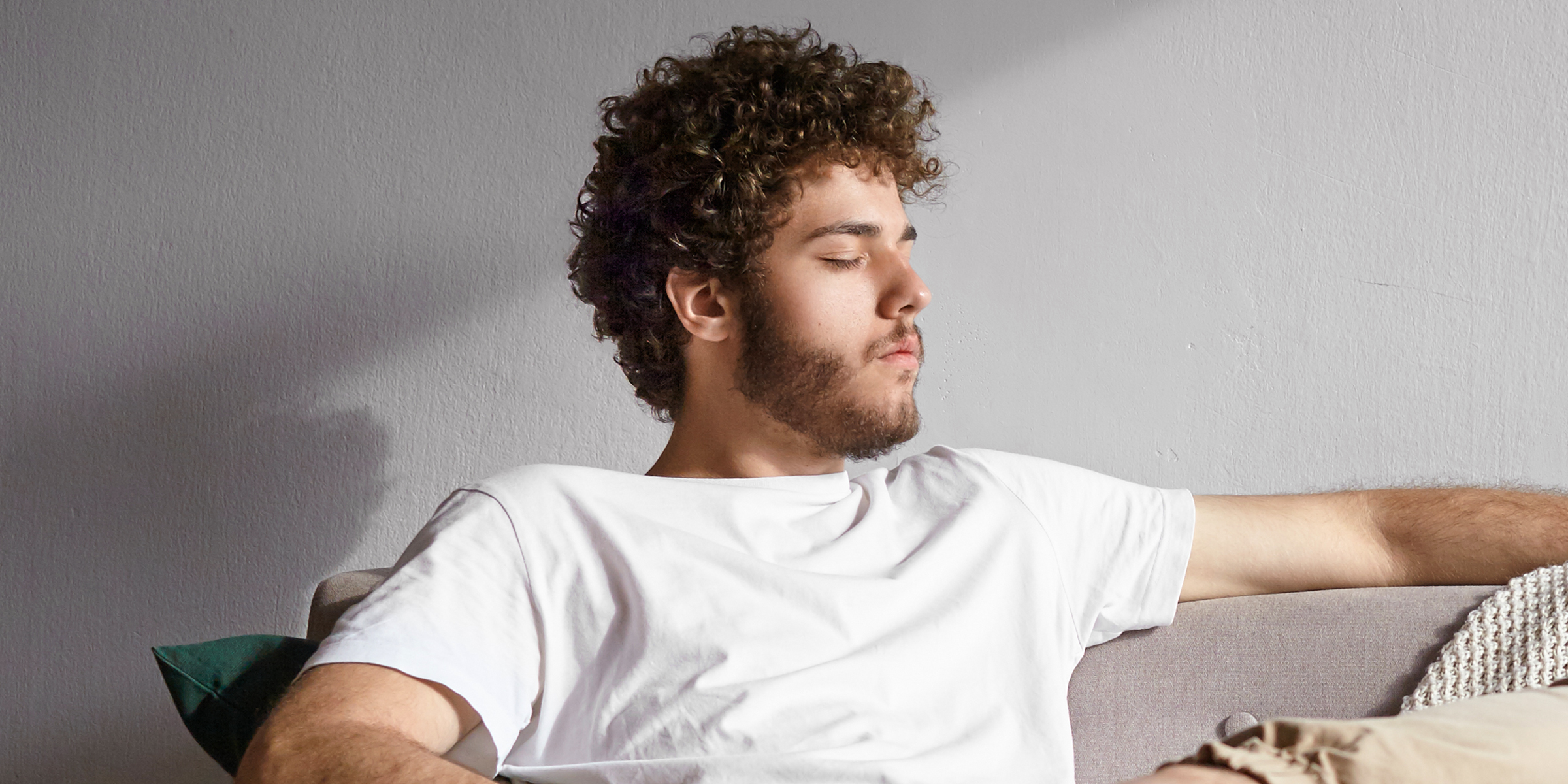 Un hombre relajándose en un sofá | Fuente: Shutterstock