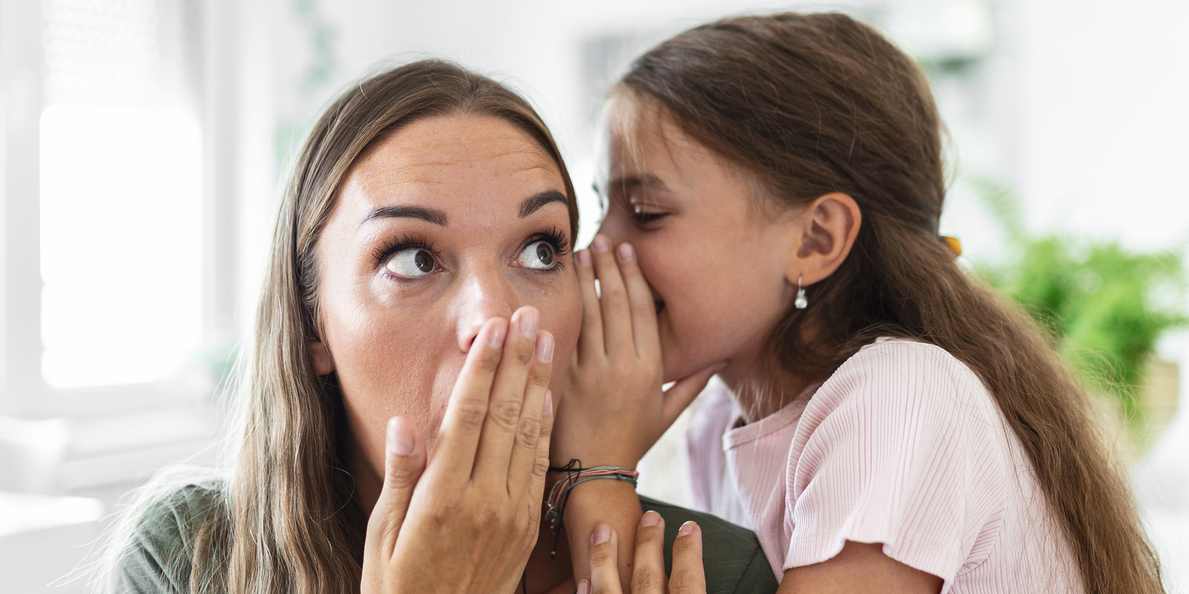 Una niña susurrando al oído de su madre | Fuente: Shutterstock