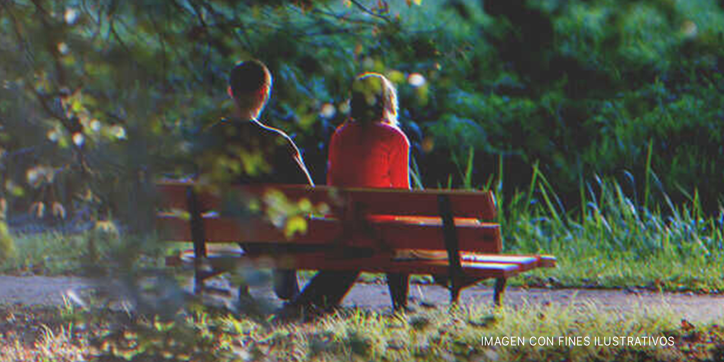 Hombre y mujer de espaldas, sentados en un banco de plaza. | Foto: Shutterstock